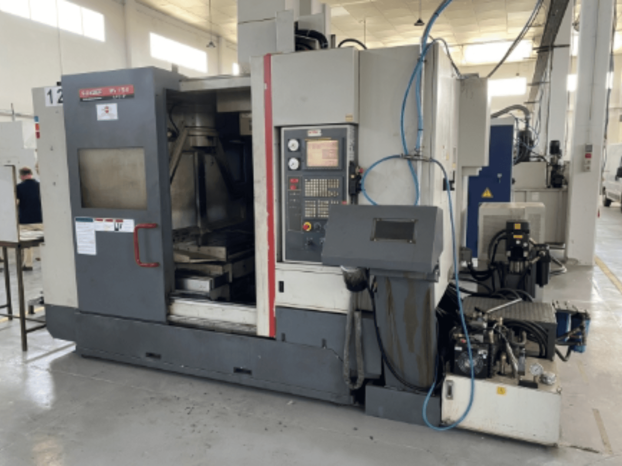 Centro de mecanizado vertical Quaser MV154APC-912, vista frontal mostrando el panel de control, la puerta abierta y los componentes de la máquina.