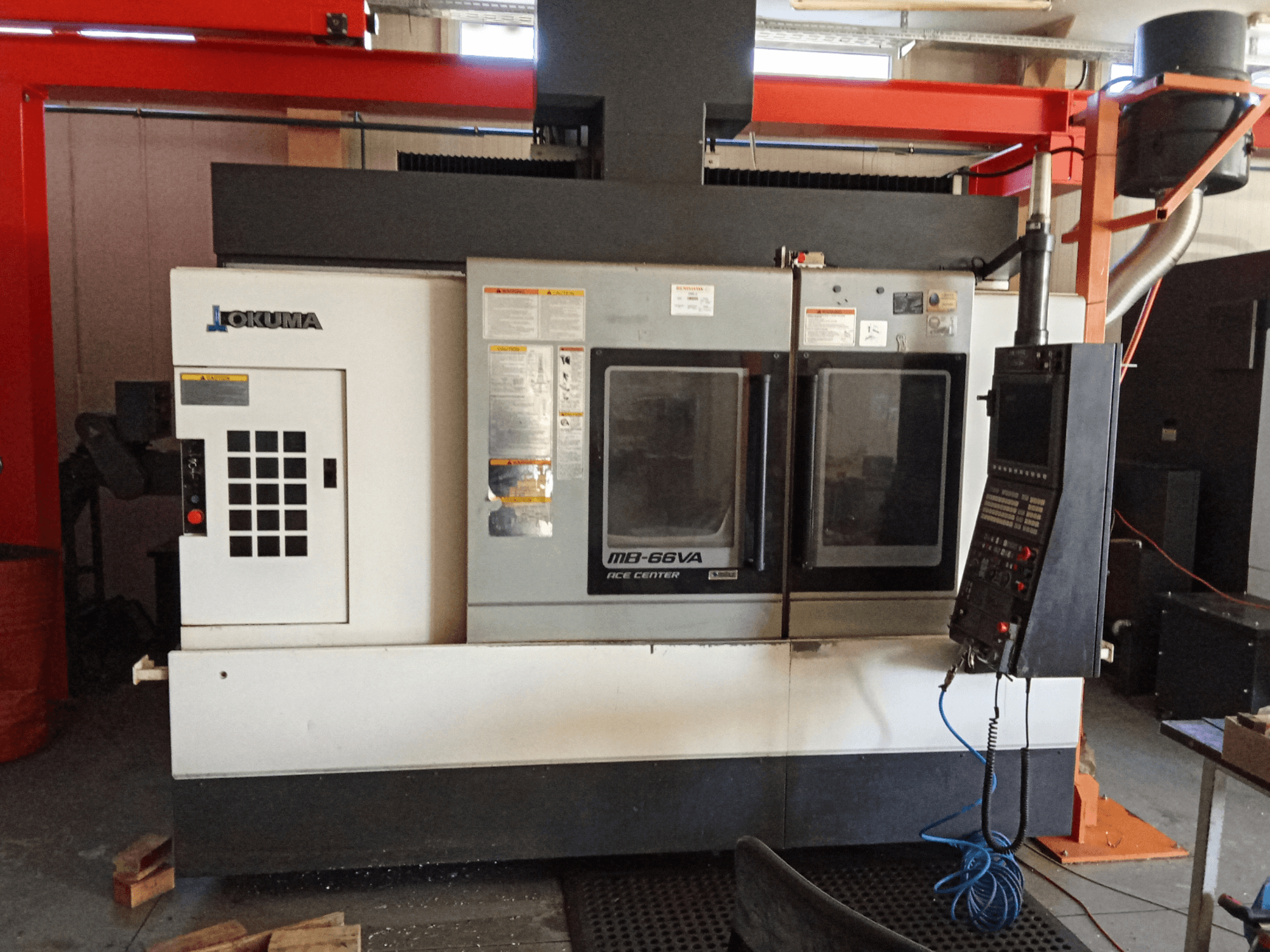 Centro de mecanizado vertical Okuma MB-66VA, vista frontal que muestra el panel de control y las ventanas de visualización dobles para acceder a las herramientas.