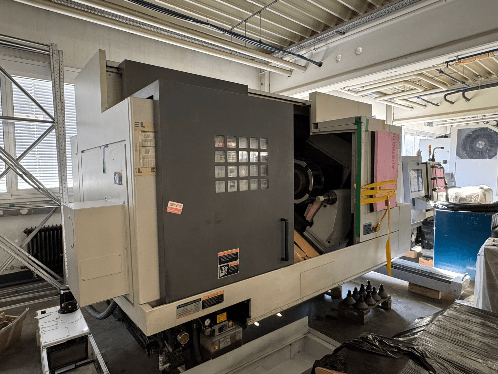 Torno horizontal MORI SEIKI NL 3000 MC/700, vista frontal con panel de control, zona de almacenamiento y cubierta protectora.