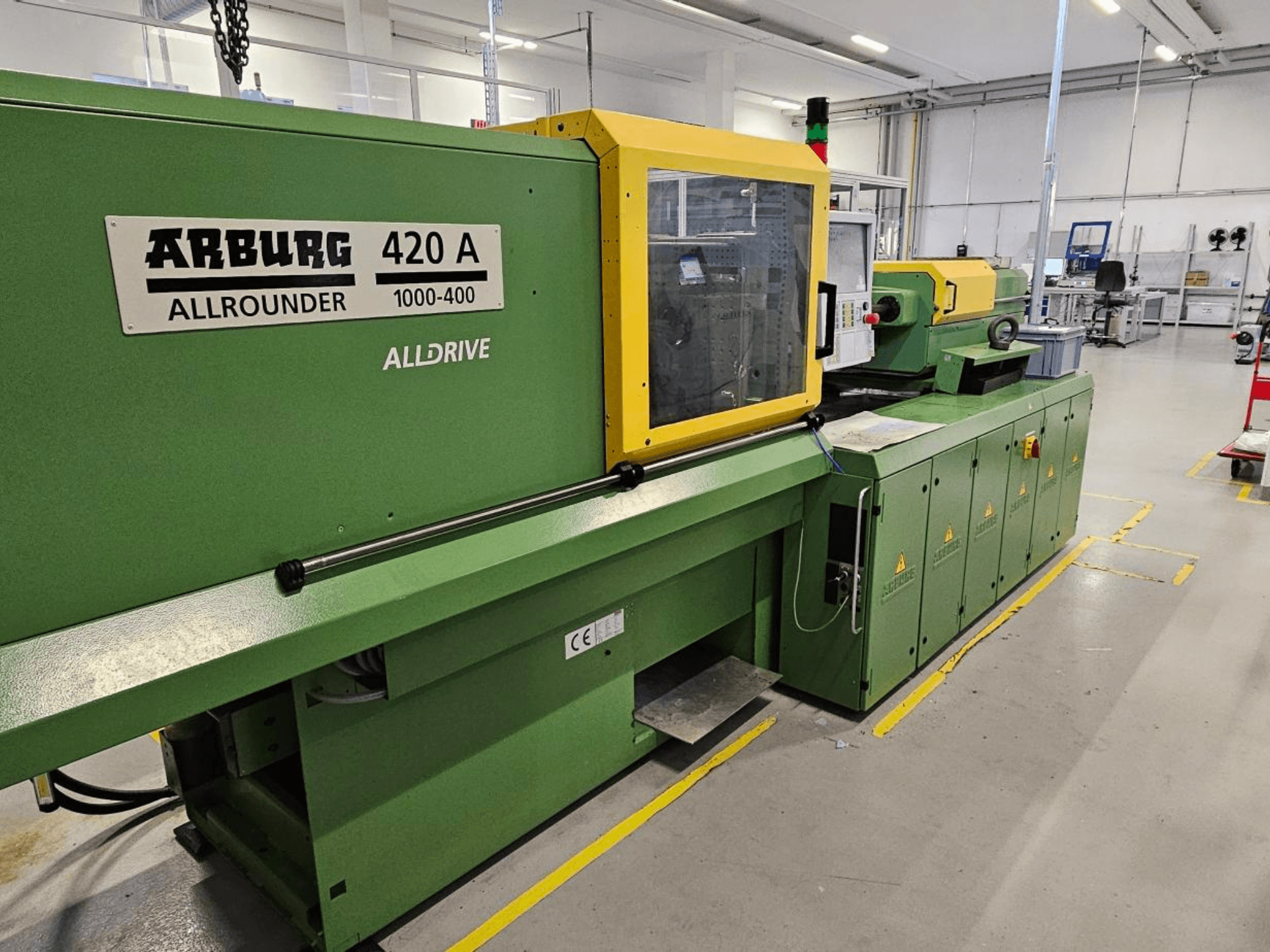 ARBURG 420 A Allrounder 1000-400, vista frontal; máquina verde con panel amarillo, pantalla táctil y dispositivos de seguridad.