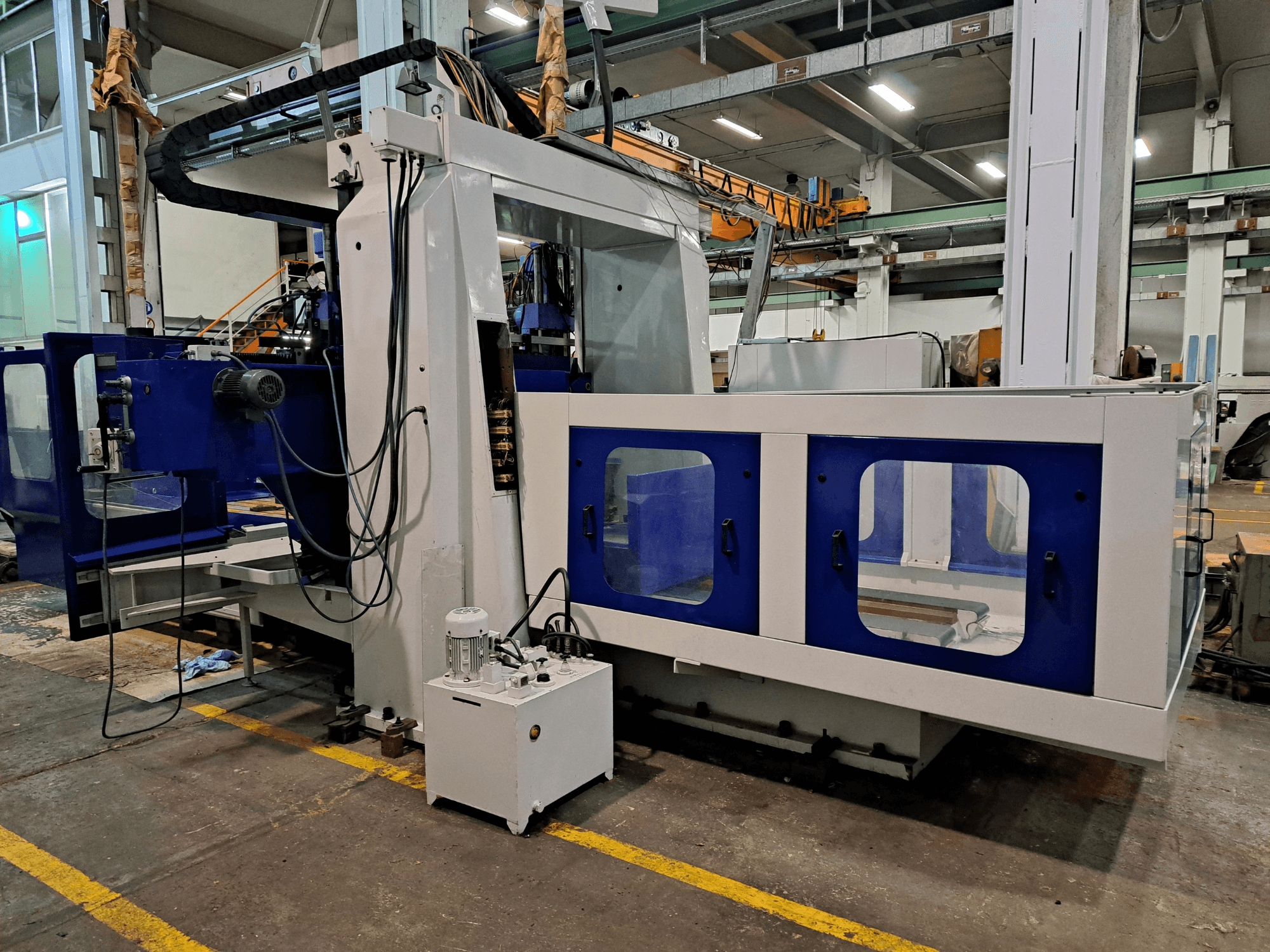 Fresadora de bancada DYE RHE-3000 en un taller; vista frontal en la que se aprecia su gran estructura azul y blanca y el panel de control.