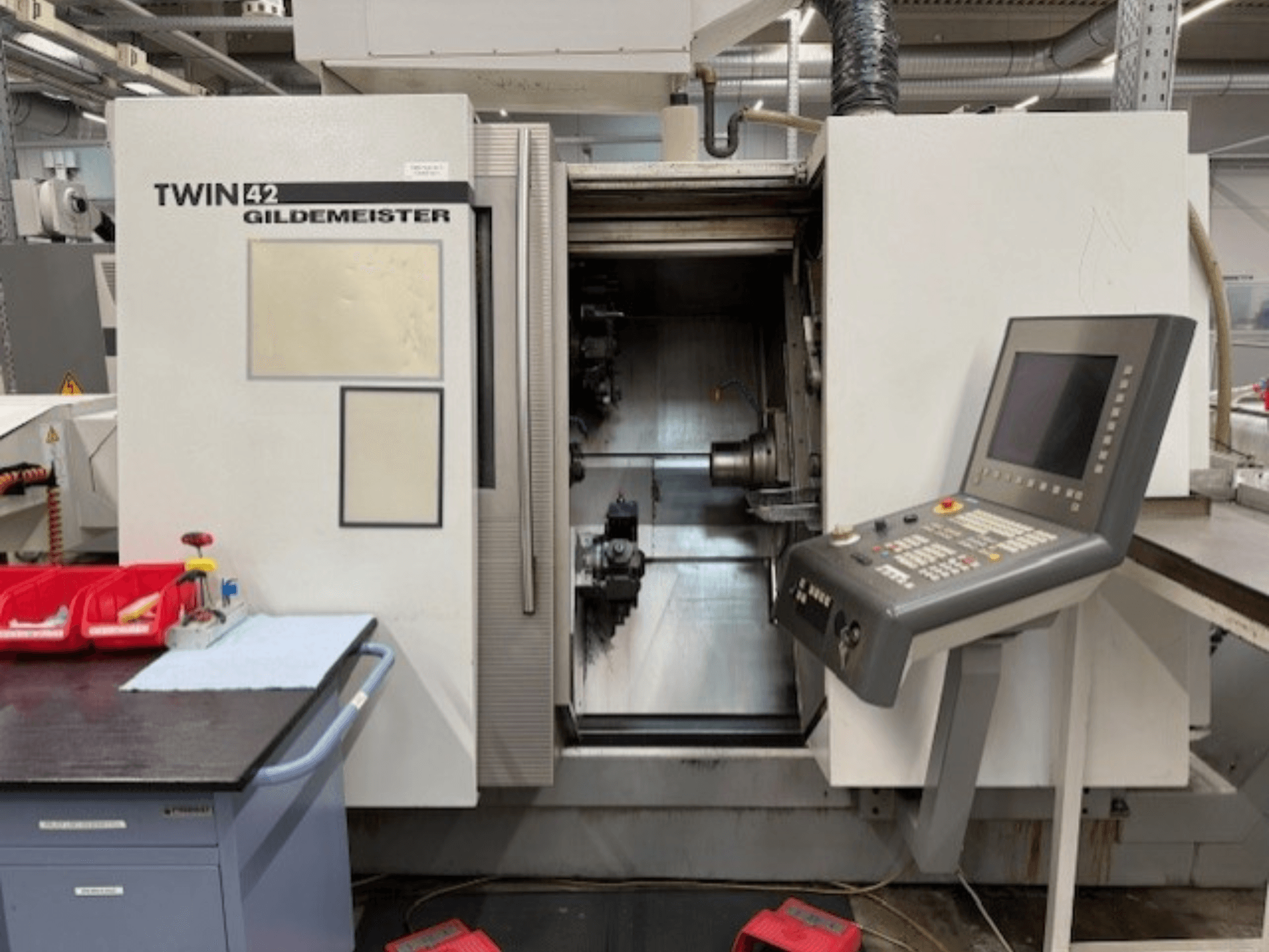 Torno horizontal Gildemeister TWIN 42; vista frontal en la que se aprecian el panel de control y la cámara del husillo abierta.