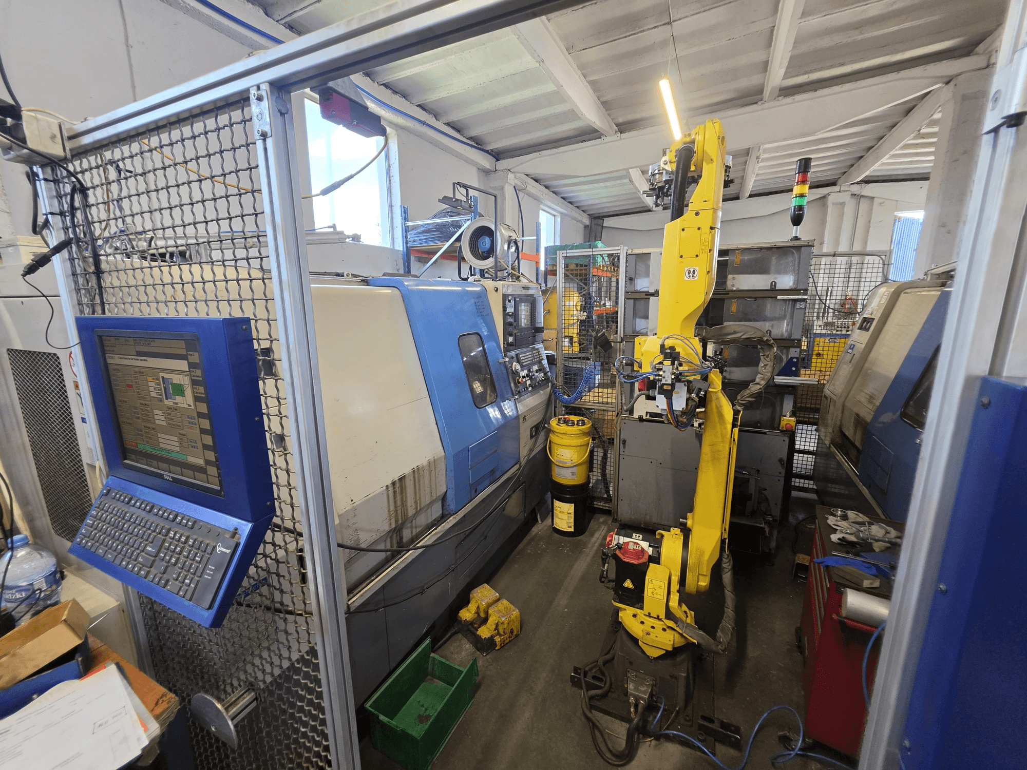 Torno horizontal Hyundai HIT-200C con robot FANUC M-20iA; vista frontal en la que se aprecian la interfaz de control y la configuración de la máquina.