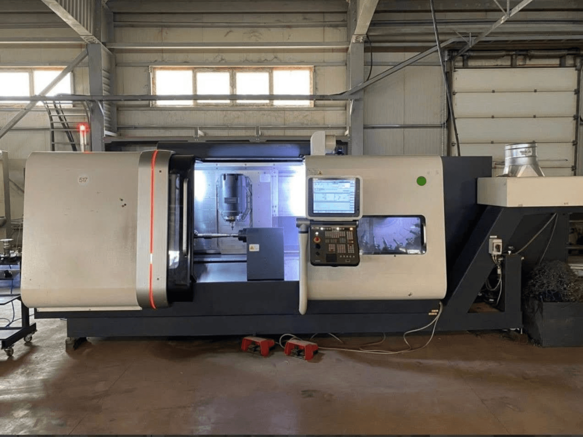 Centro de torneado y fresado DMG MORI Beta 1250 TC, vista frontal con panel de control, espacio de trabajo iluminado y herramientas de corte visibles.