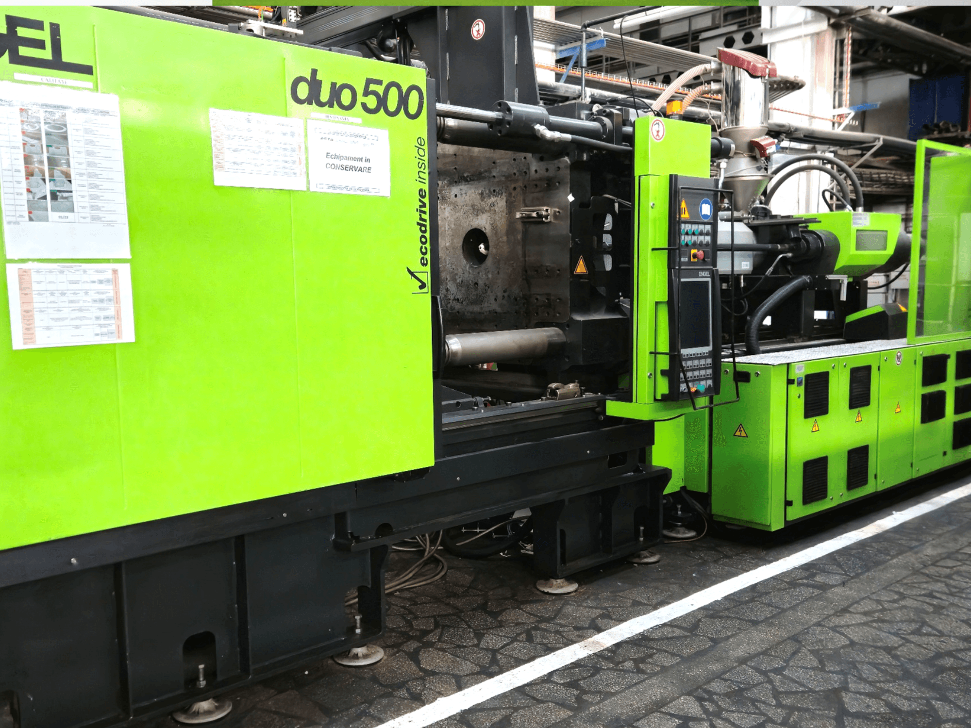 Máquina industrial verde Ergotron duo 500, vista frontal; con panel de control, detalles técnicos y etiquetas de seguridad del equipo.