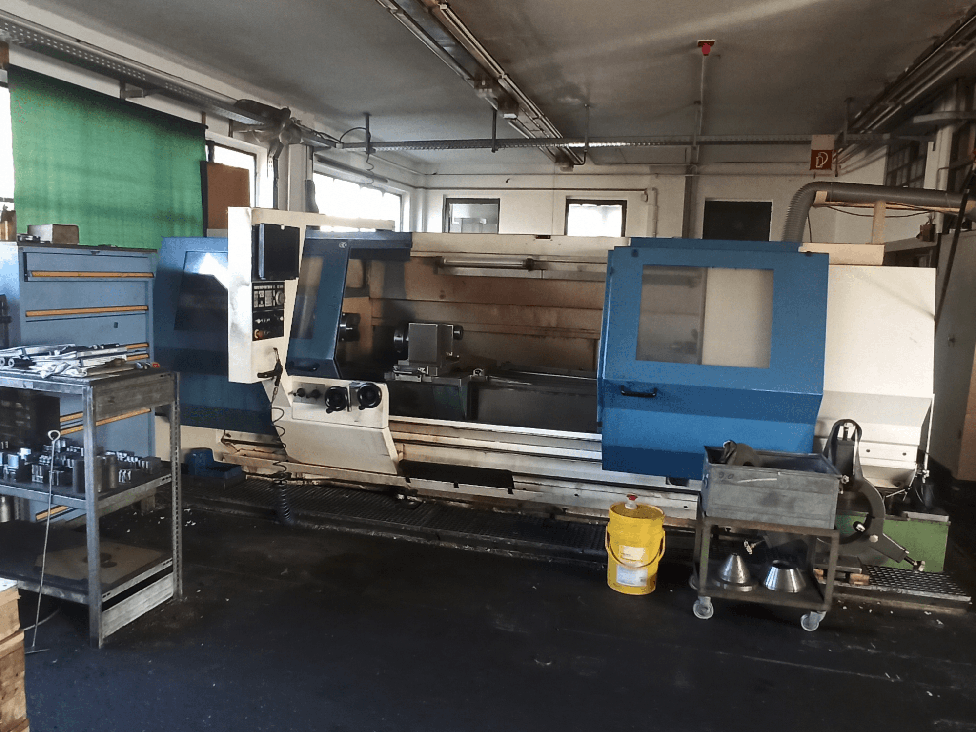 Torno horizontal BOEHRINGER DUC 560/2000 en un taller, en el que se aprecian el panel de control y el espacio de trabajo en una vista lateral.