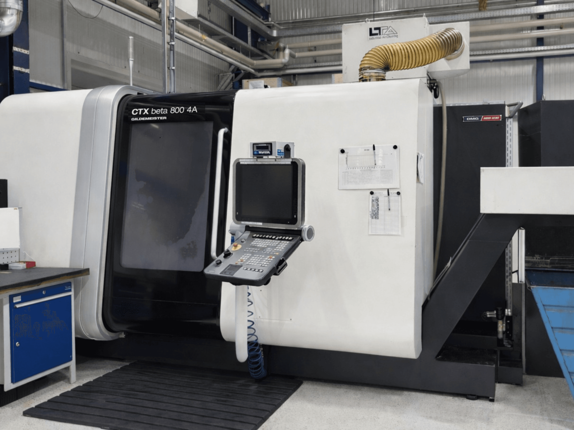 Torno multihusillo DMG CTX beta 800 4A, vista frontal, en la que se aprecian el panel de control y la documentación operativa.