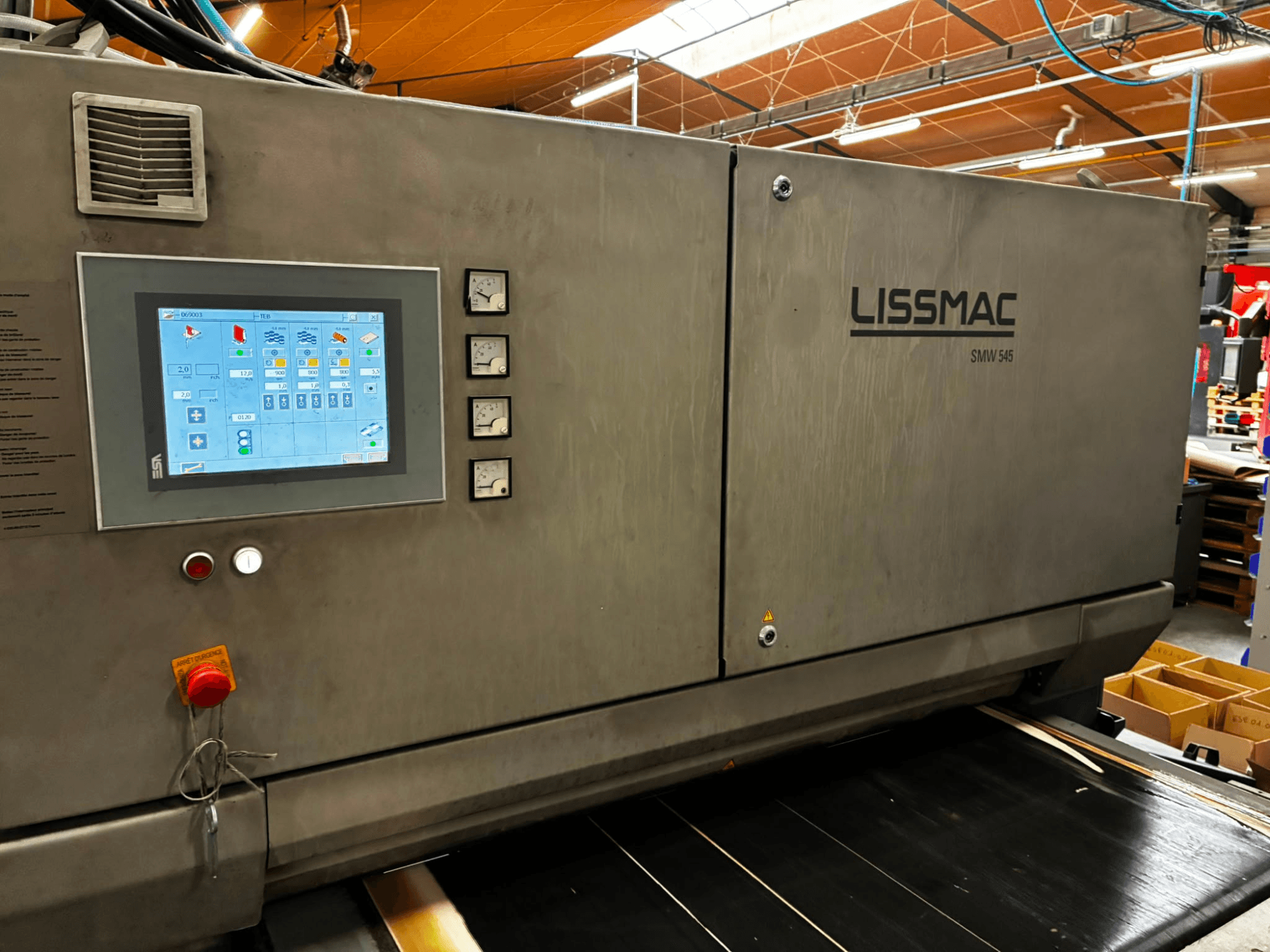 Máquina desbarbadora LISSMAC SMW 545 RTTB vista de perfil, equipada con un panel de control con pantalla táctil e indicadores.