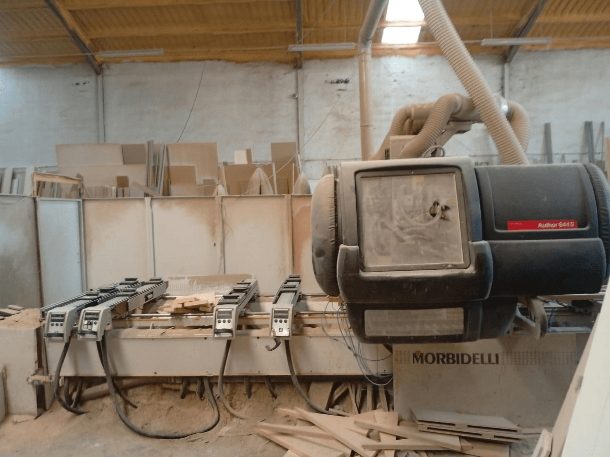 Centro de mecanizado CNC MORBIDELLI A644S FTP 41 PC expuesto en un taller, en el que se aprecia una vista frontal con polvo y restos de madera.