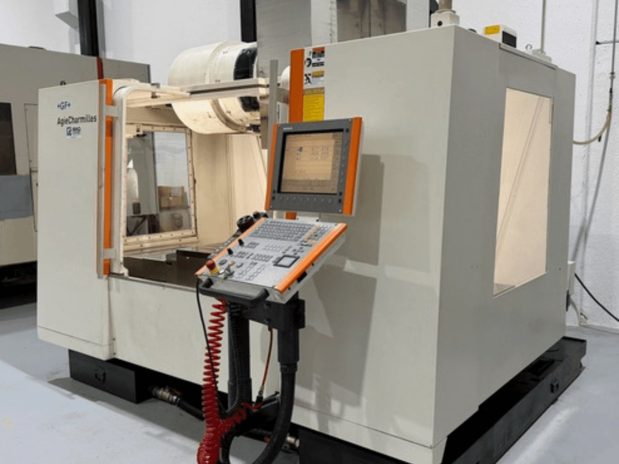 Fresadora GF AgieCharmilles MIKRON en vista lateral, con un panel de control con botones y una pantalla de visualización.