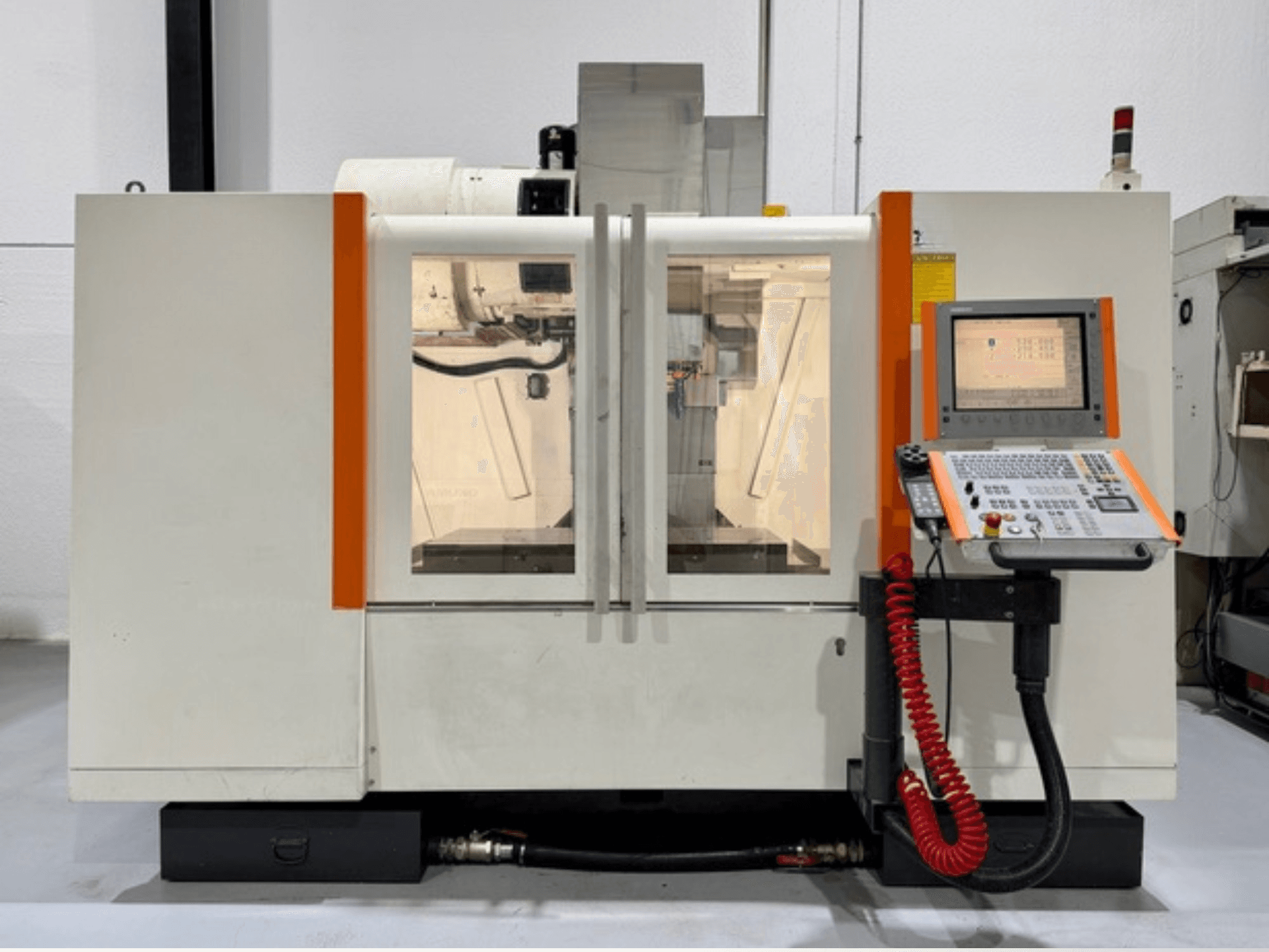 Máquina CNC con detalles en naranja, vista frontal. Incluye panel de control y funcionamiento interior visible.
