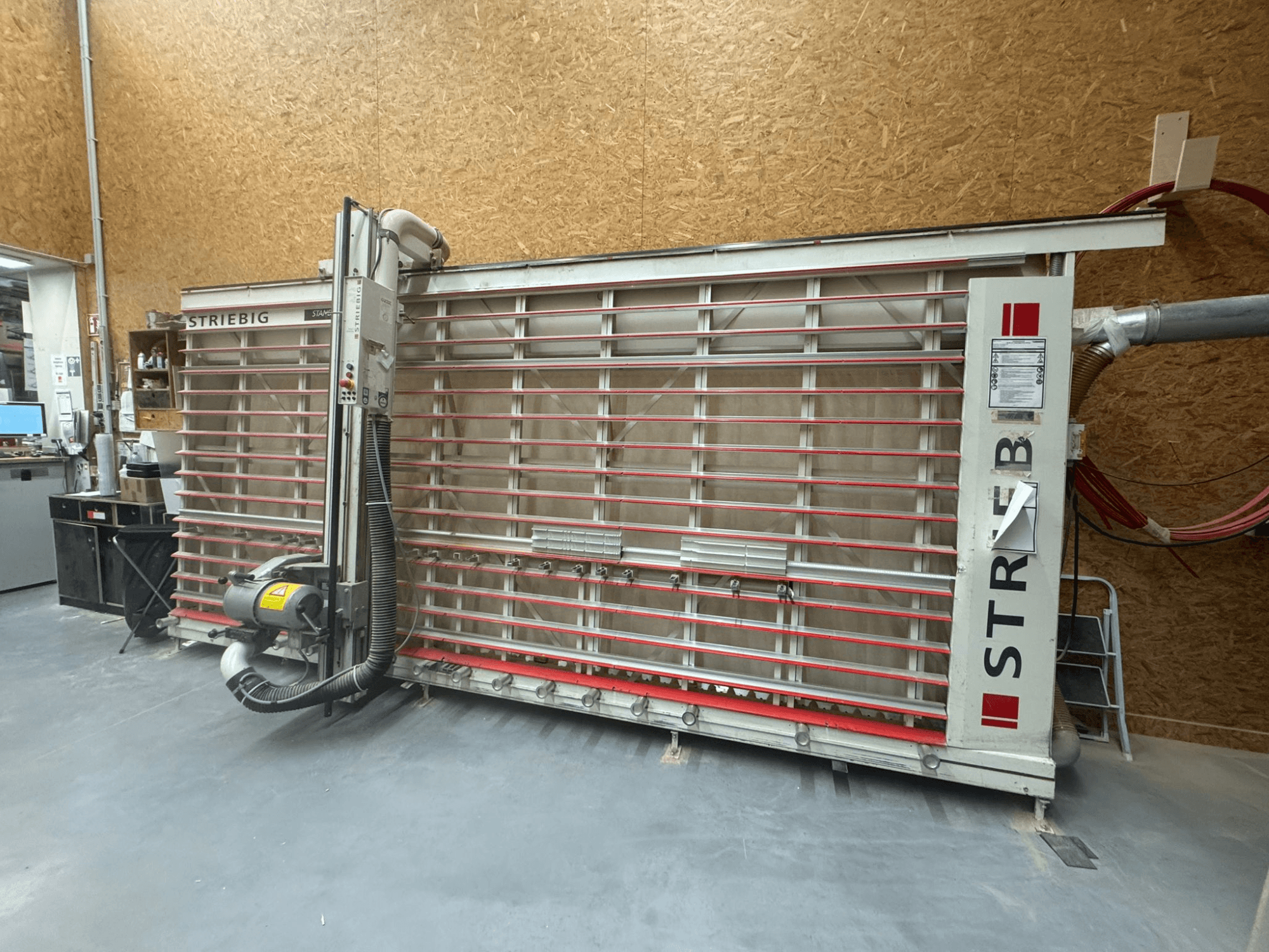 Sierra de contornos STRIEBIG con una gran hoja vertical, vista lateral que muestra la aspiración de polvo y el panel de control. Ideal para trabajar la madera.