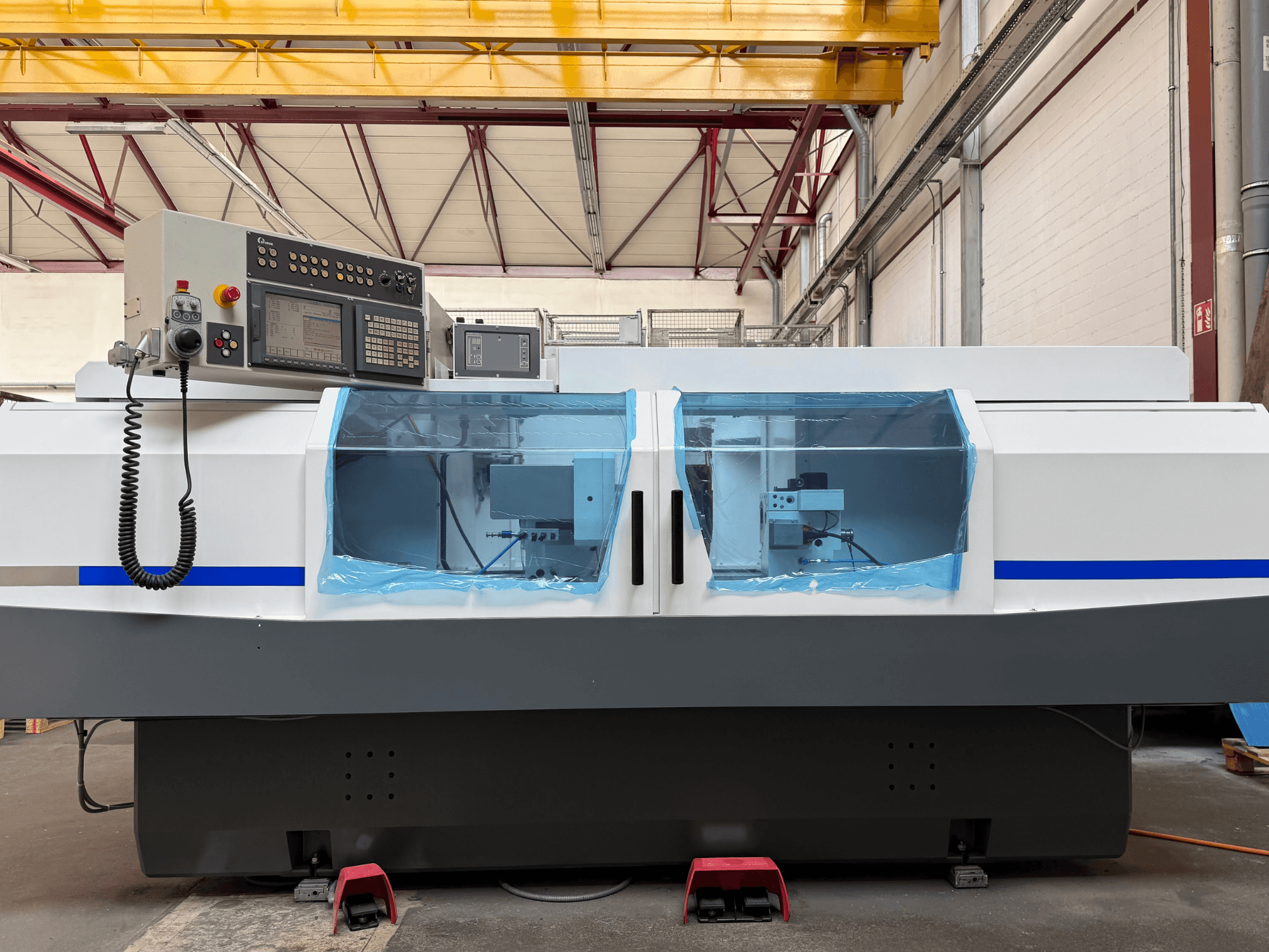Rectificadora cilíndrica STUDER S33 CNC vista de perfil, con panel de control y cubiertas de seguridad transparentes.