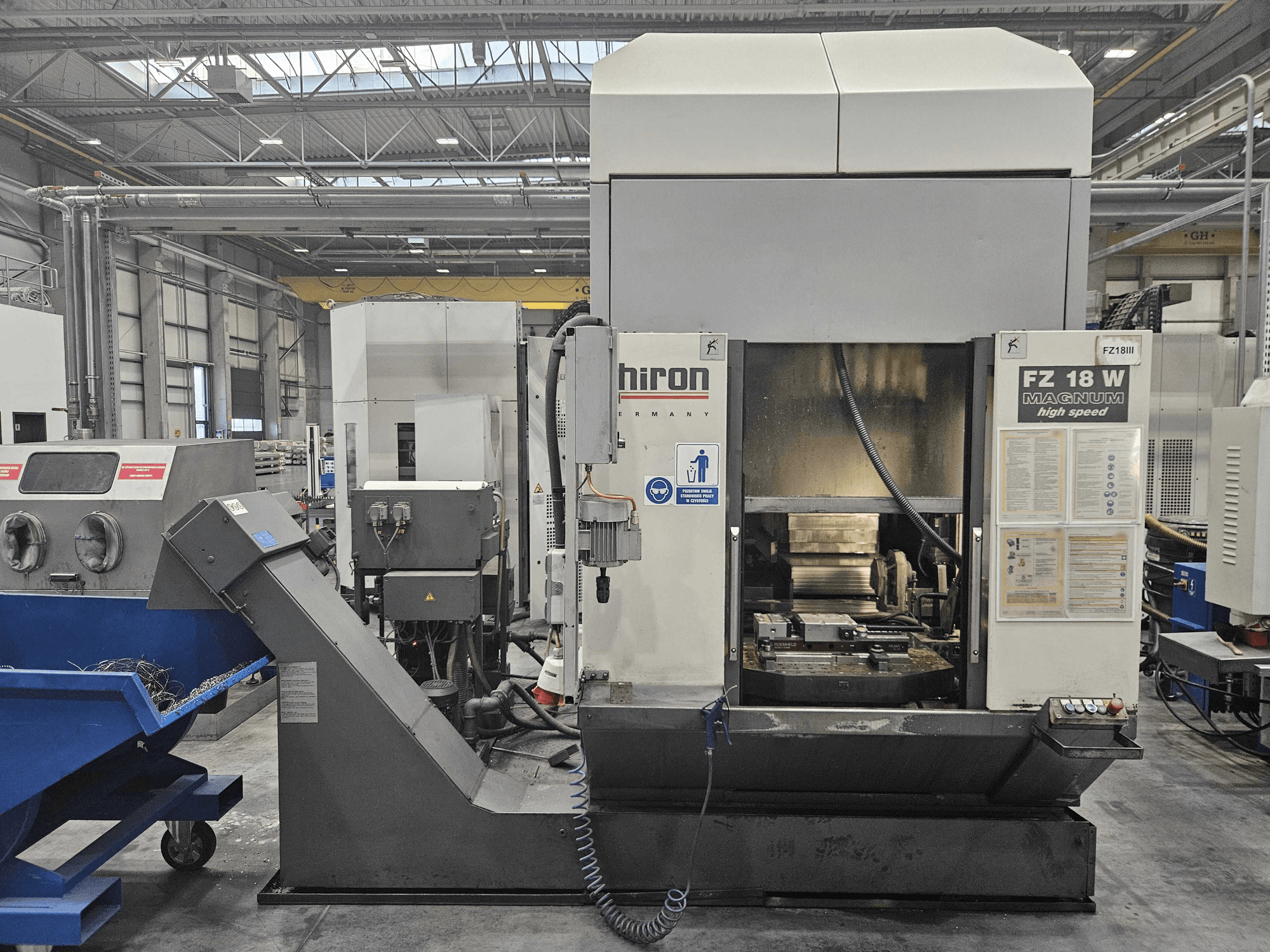 Máquina Hiron FZ 18 W Magnum, vista frontal, mostrando el panel de control, el husillo y el vertedero de residuos adjunto.