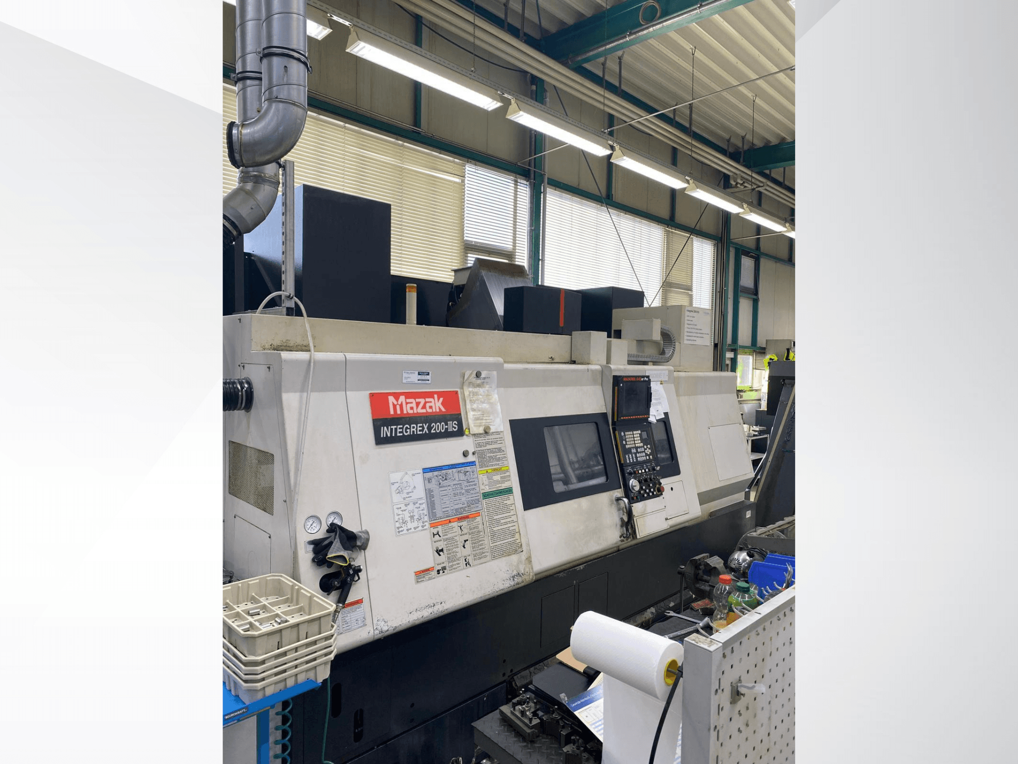 Centro de torneado y fresado Mazak INTEGREX 200 III S, vista lateral, en la que se aprecian el panel de control, los indicadores y las herramientas del espacio de trabajo.