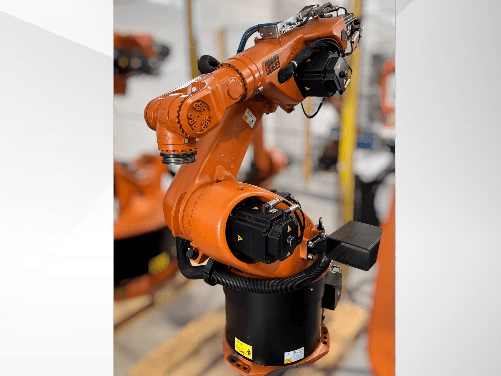 Brazo robótico KUKA KR 60-3 en naranja; vista lateral que muestra la base, las articulaciones y los módulos de control para tareas de automatización.