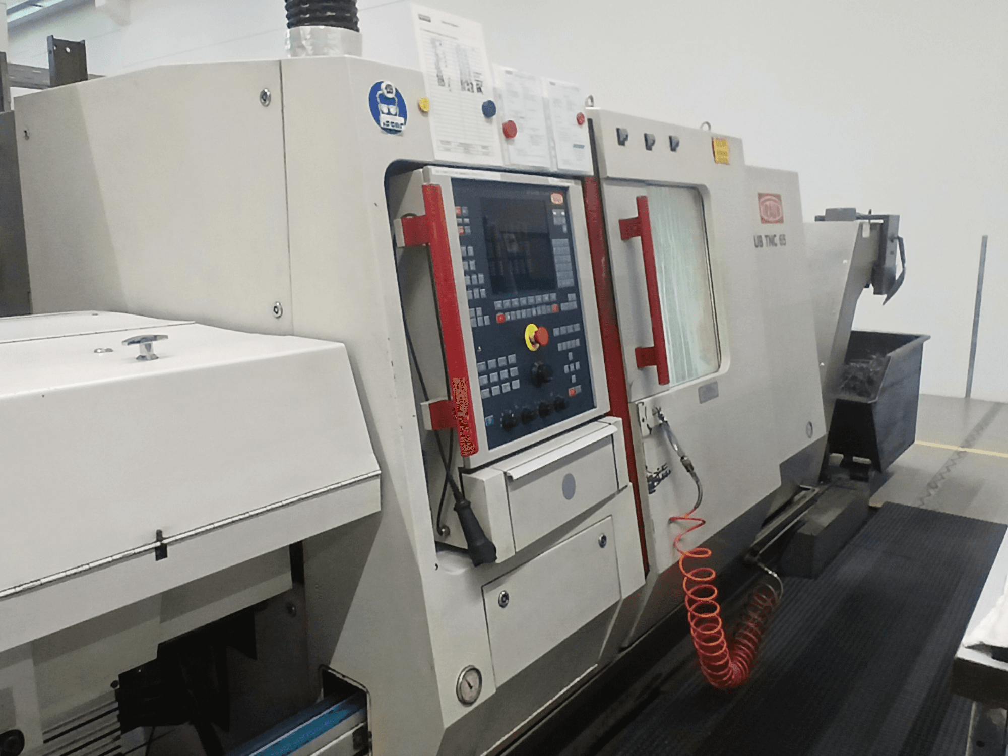 Torno horizontal TRAUB TNC65 DG, vista frontal, mostrando panel de control y herramientas, ideal para mecanizado de precisión.