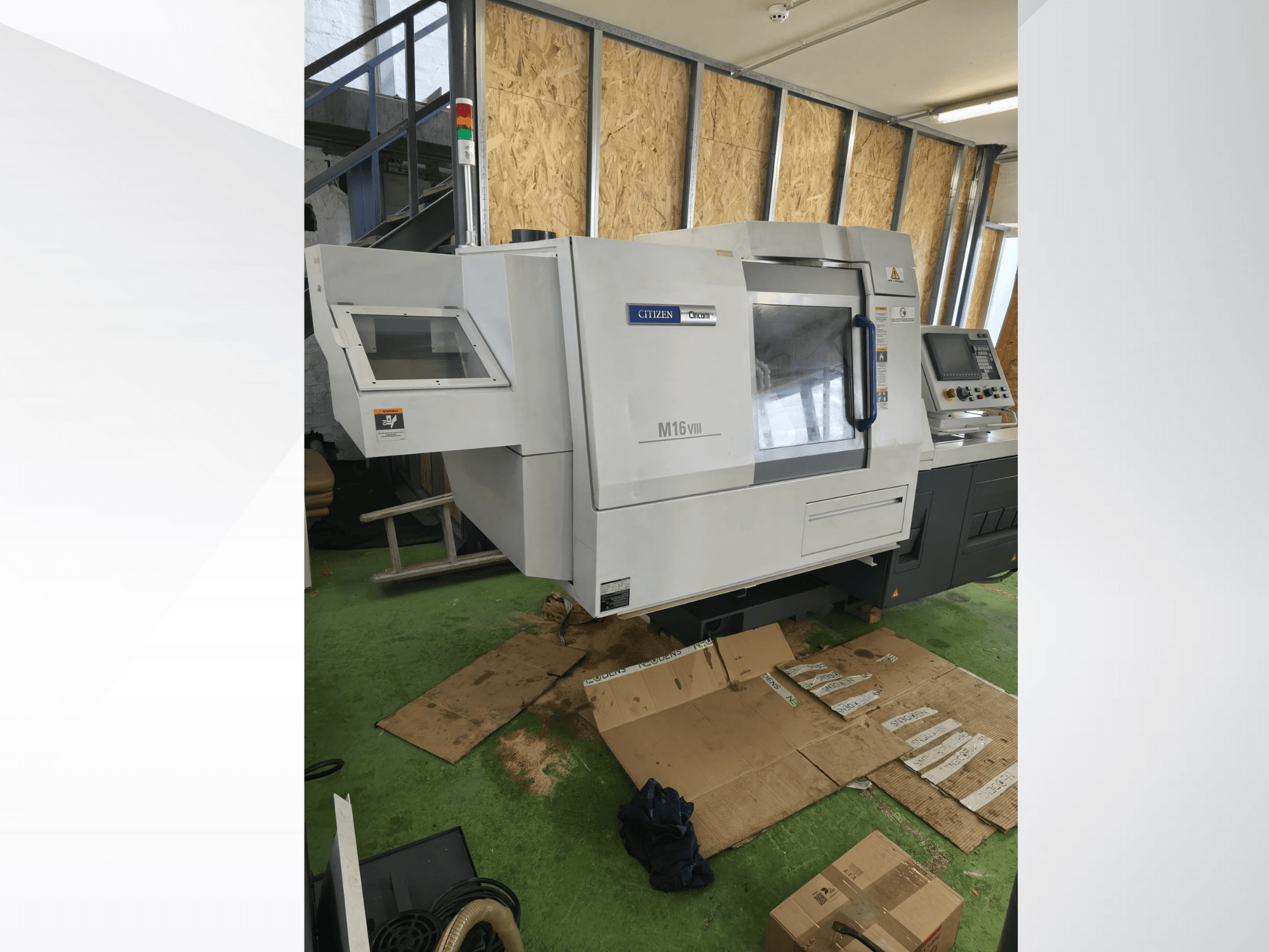 Torno CNC Citizen M16VIII en vista frontal, dispone de panel de control y luces de alerta de seguridad, colocado sobre pavimento verde.