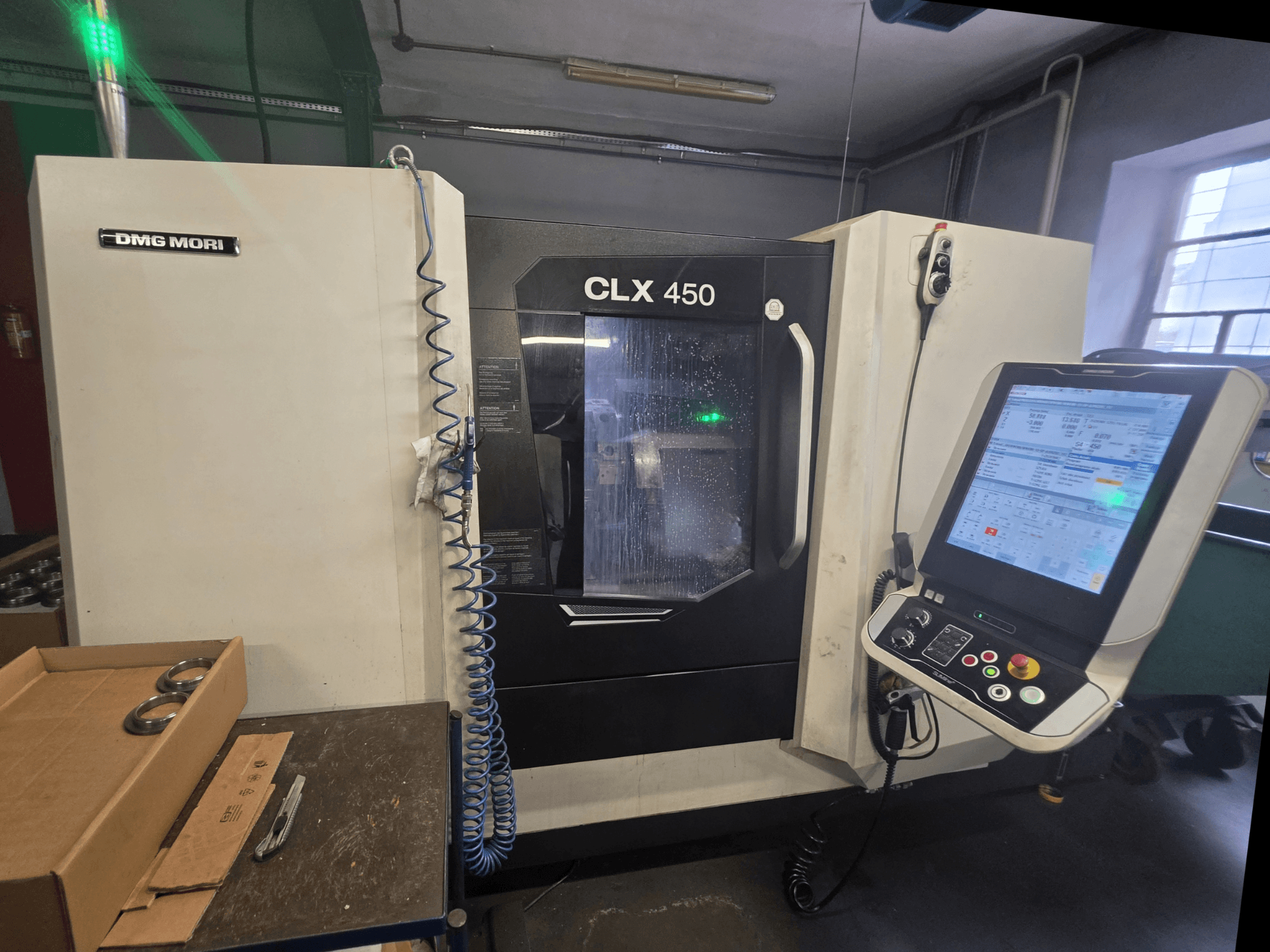 Vista frontal del torno horizontal DMG MORI CLX 450 V3, en la que se aprecian el panel de control, el sistema de refrigeración y la zona de trabajo.