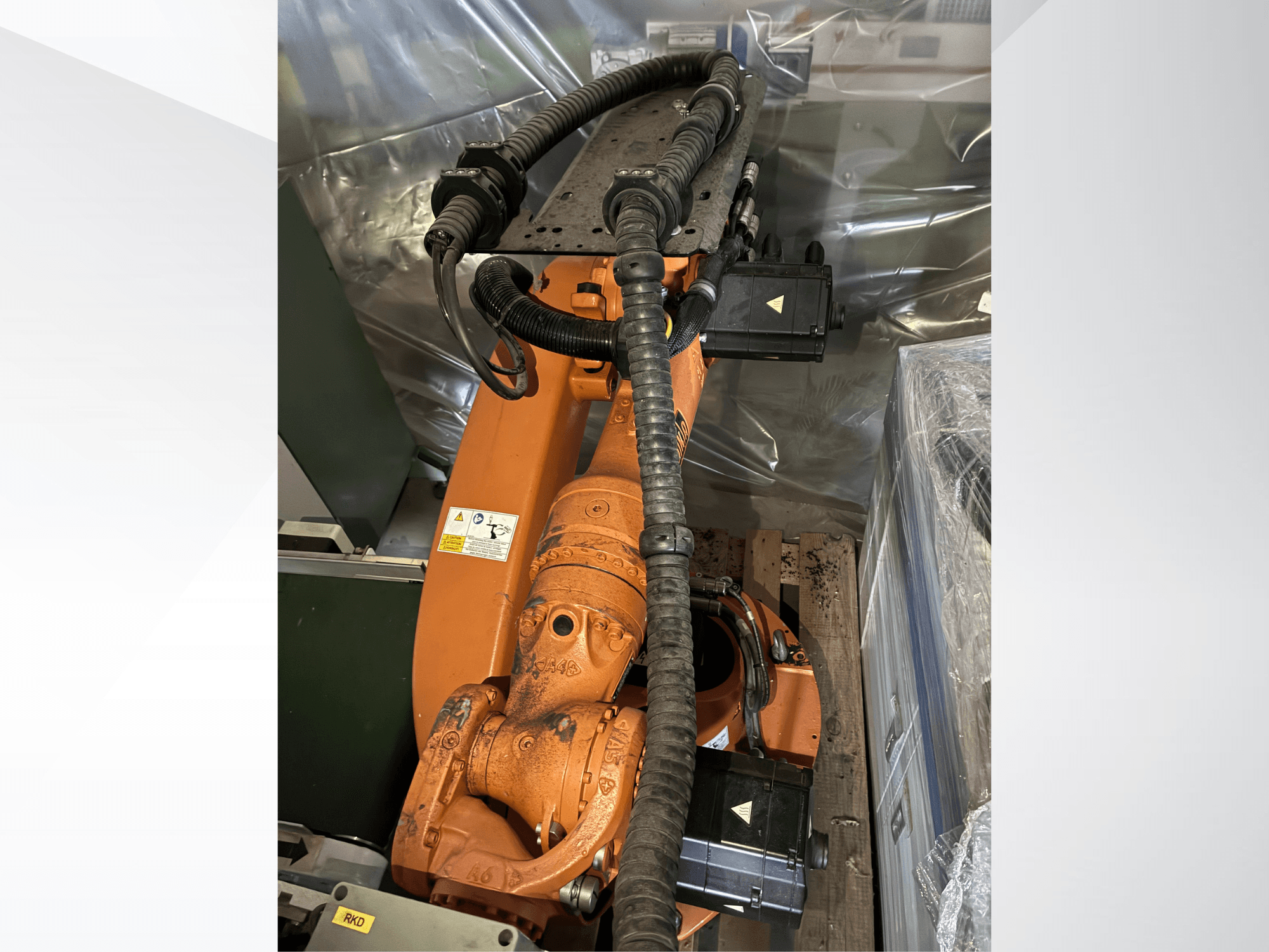 Brazo robótico KUKA KR16-2 de color naranja, visto desde arriba, en el que se aprecian los conectores y los tubos protectores.