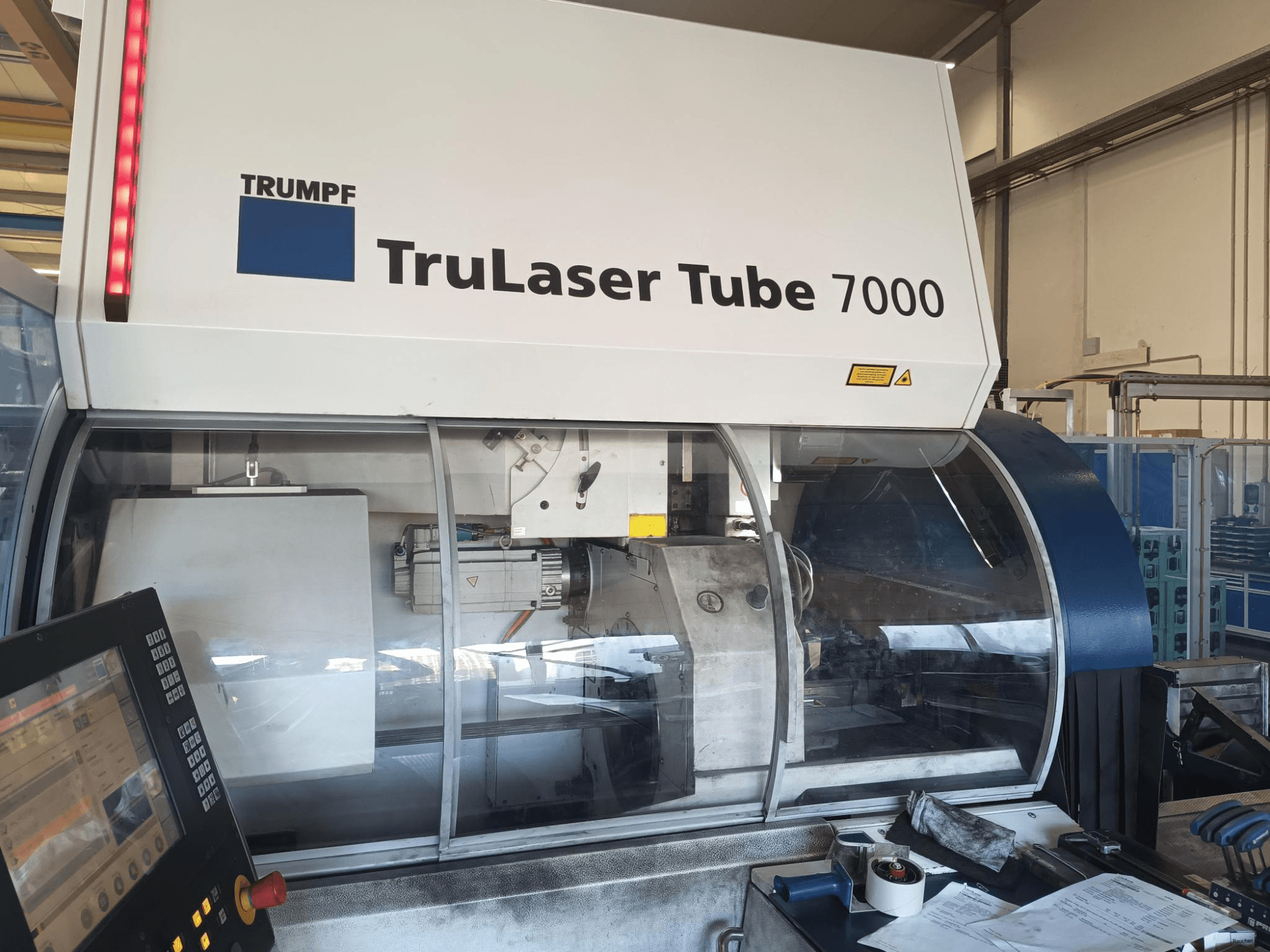 TRUMPF TruLaser Tube 7000, vista frontal de la máquina con panel de control, mostrando las características de corte por láser y el espacio de trabajo.