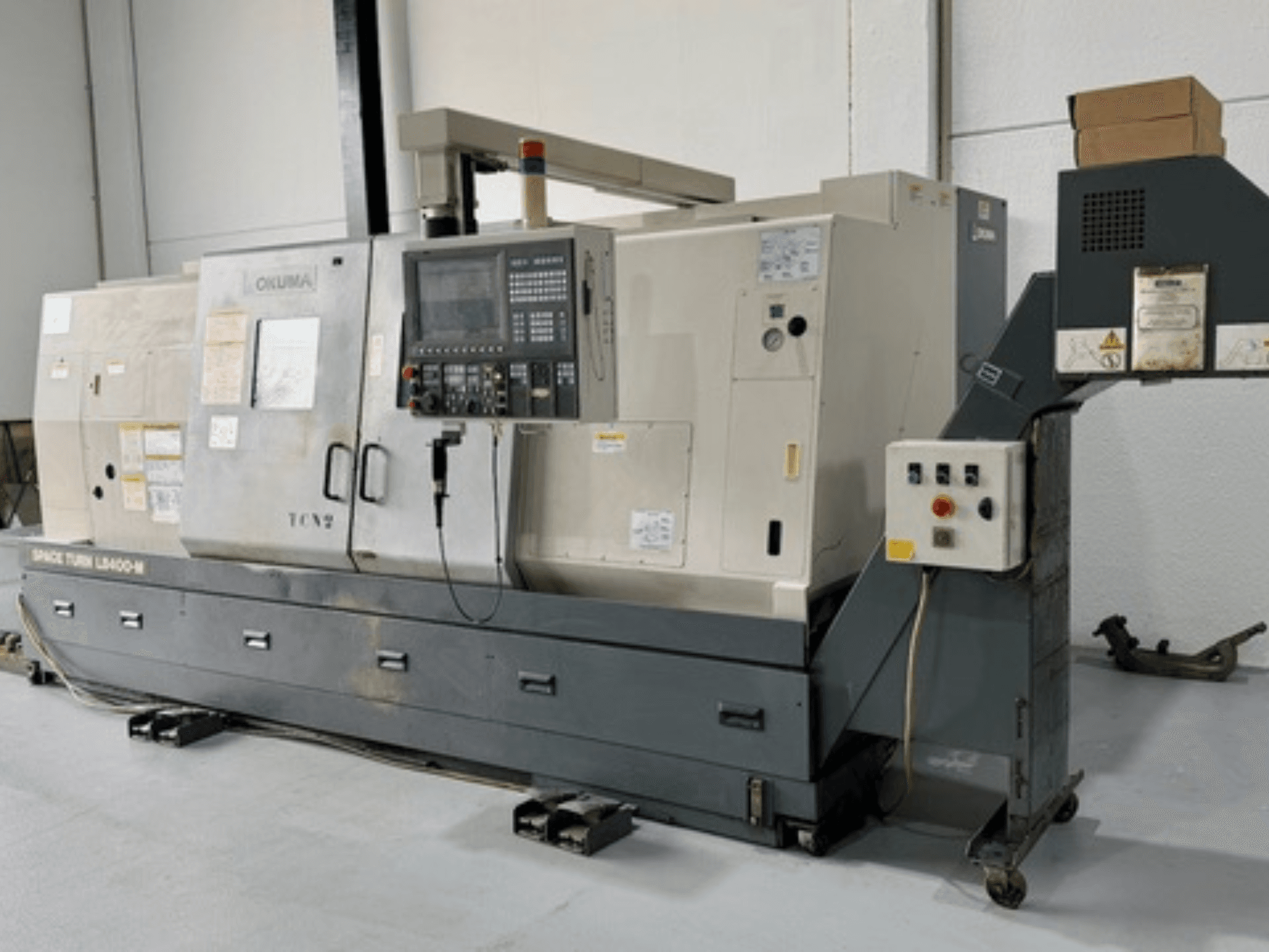 Máquina de torno Okuma Space Turn LB400-M, vista frontal con panel de control, con múltiples interruptores y especificaciones detalladas.