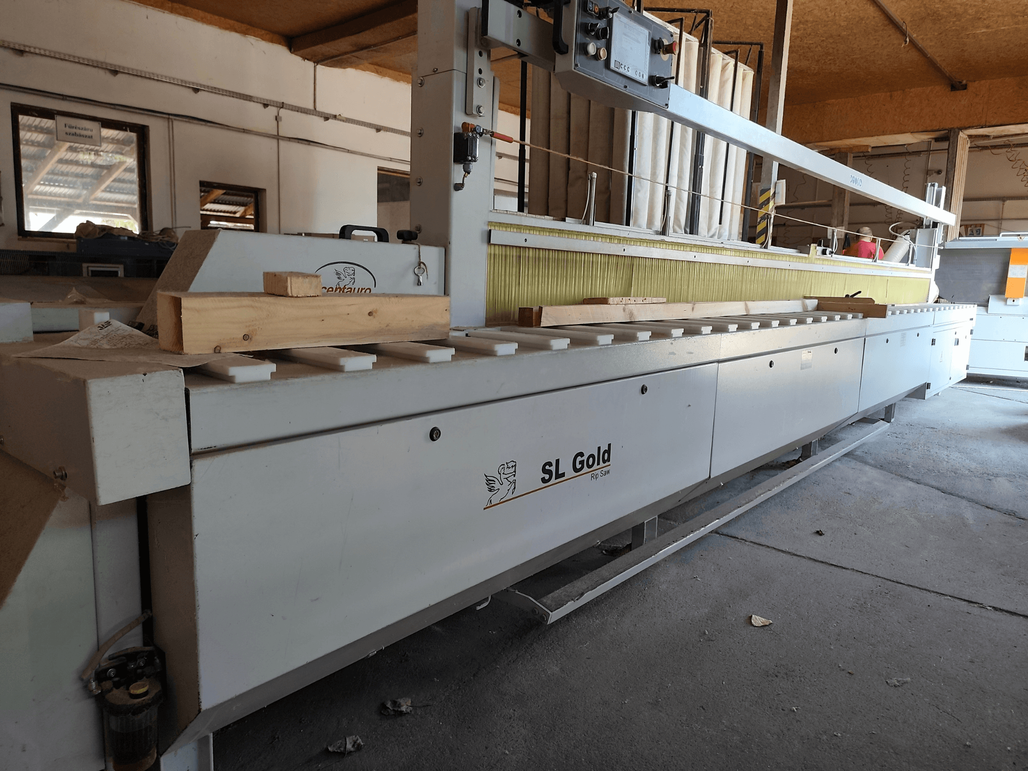 Sierra circular para madera CENTAURO SL Gold 6000, vista frontal, con una pieza de madera sobre la superficie de trabajo y los mandos de funcionamiento a la vista.