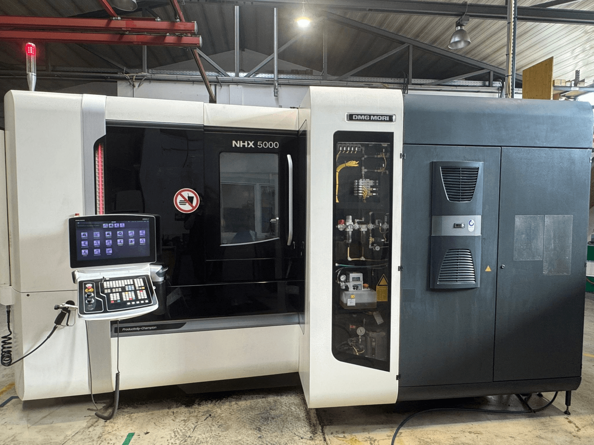 Vista frontal del centro de mecanizado horizontal DMG MORI NHX 5000, mostrando el panel de control y los detalles de la máquina.