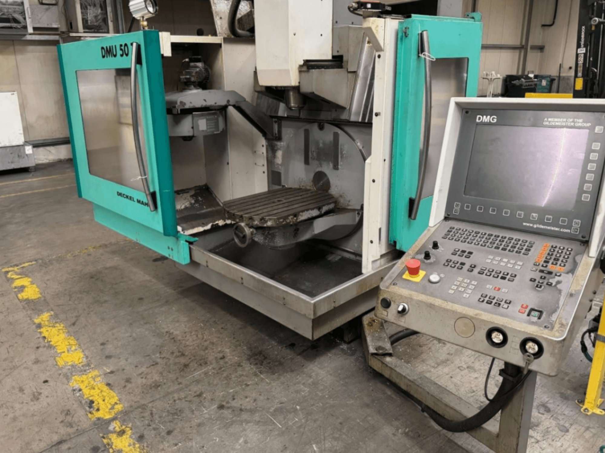 Fresadora DMG DMU 50 con las puertas abiertas mostrando el interior y el panel de control, vista de frente.