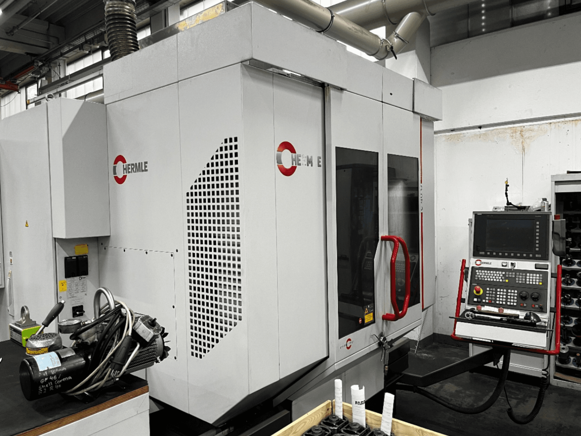 Centro de mecanizado universal HERMLE C40U en un taller, vista frontal, mostrando el panel de control y el diseño detallado de la máquina.