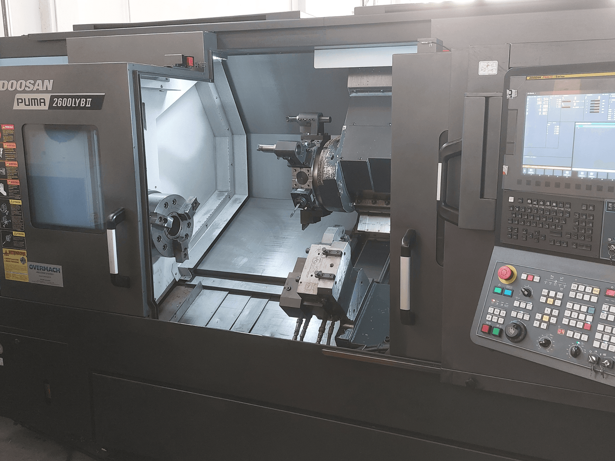 Máquina de torneado horizontal DOOSAN Puma 2600 LYB II en vista frontal, mostrando el interior con mandril, portaherramientas y panel de control.