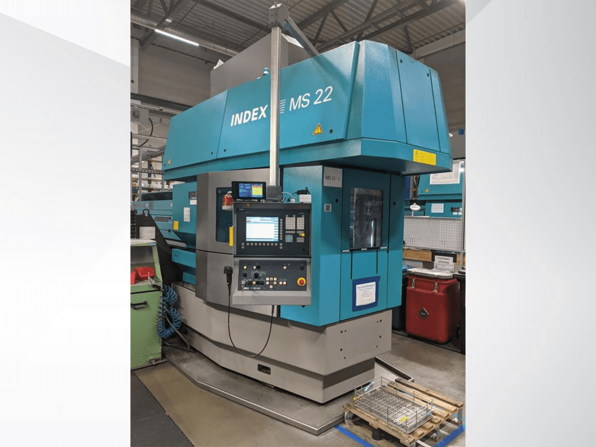 Torno multihusillo Index MS 22 en un entorno industrial, vista frontal en la que se aprecian el panel de control y el exterior azul.