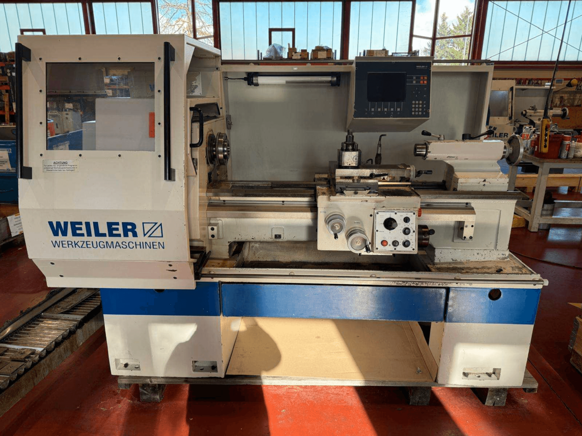 Máquina de torneado horizontal Weiler E35 en vista frontal, con panel de control y componentes de torno.