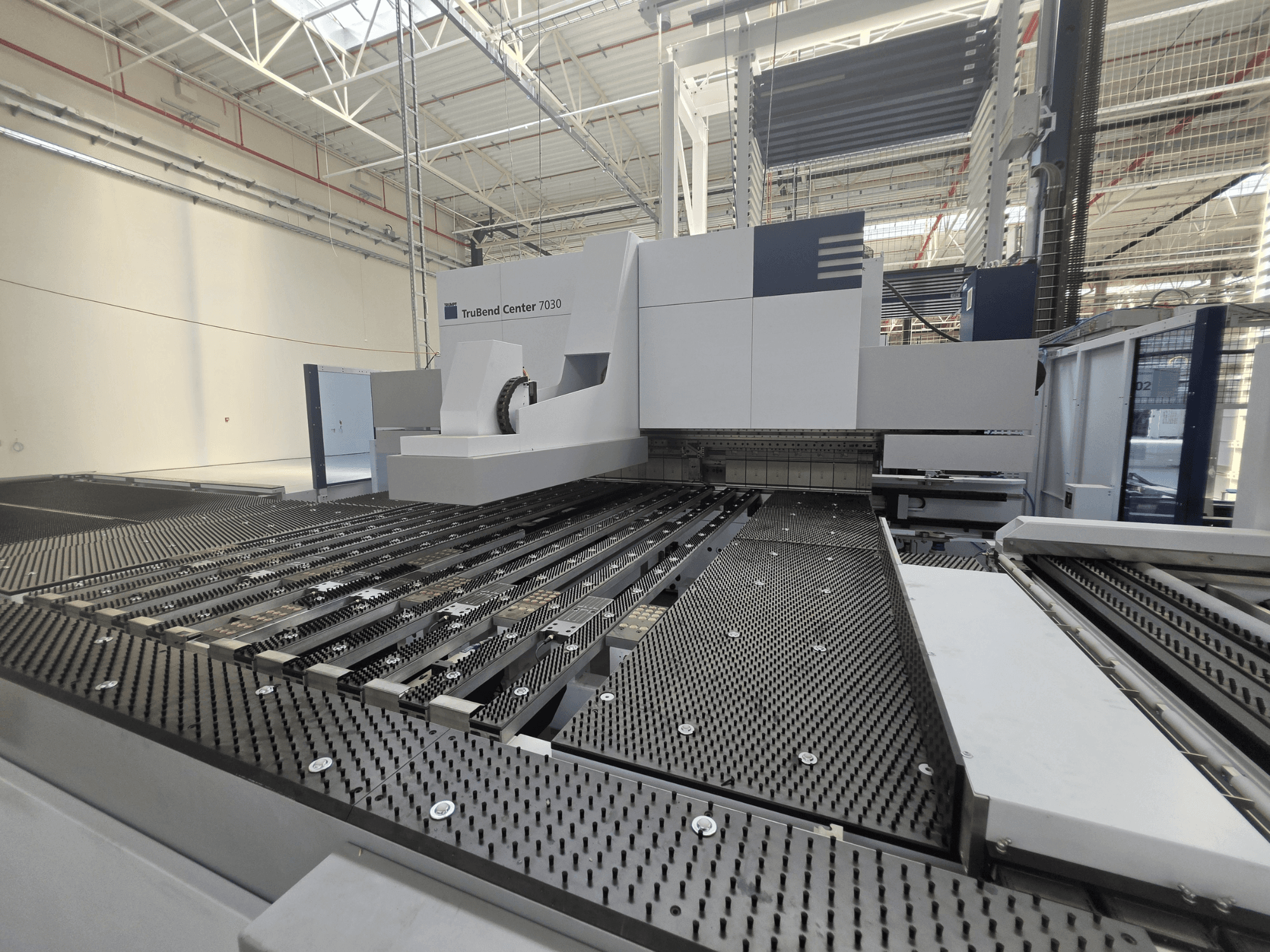 Plegadora TRUMPF TruBend Center 7030 en un entorno industrial; vista frontal en la que se aprecian la compleja mesa de trabajo y el brazo de plegado.