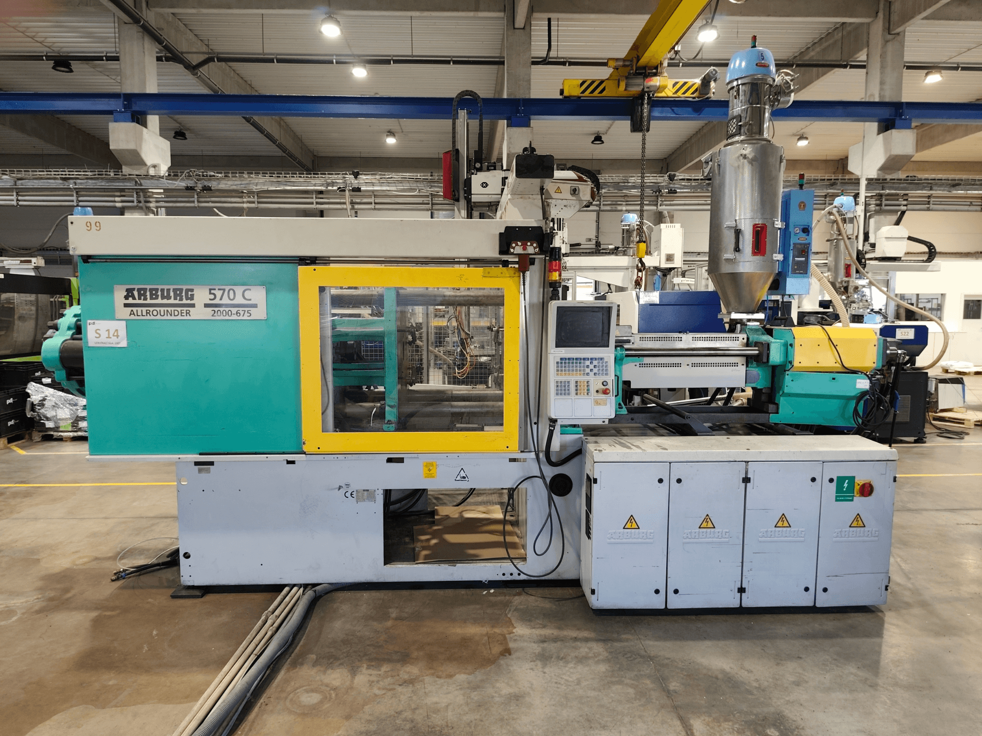 Máquina de moldeo por inyección hidráulica Arburg Allrounder 570 C 2000-675, vista frontal, en la que se aprecian el panel de control y la tolva de material.