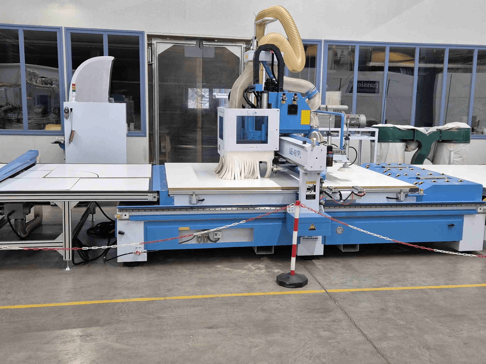 Ruteadora CNC azul UE-621PL de frente, con una gran mesa de corte y un sistema de extracción de polvo incorporado.
