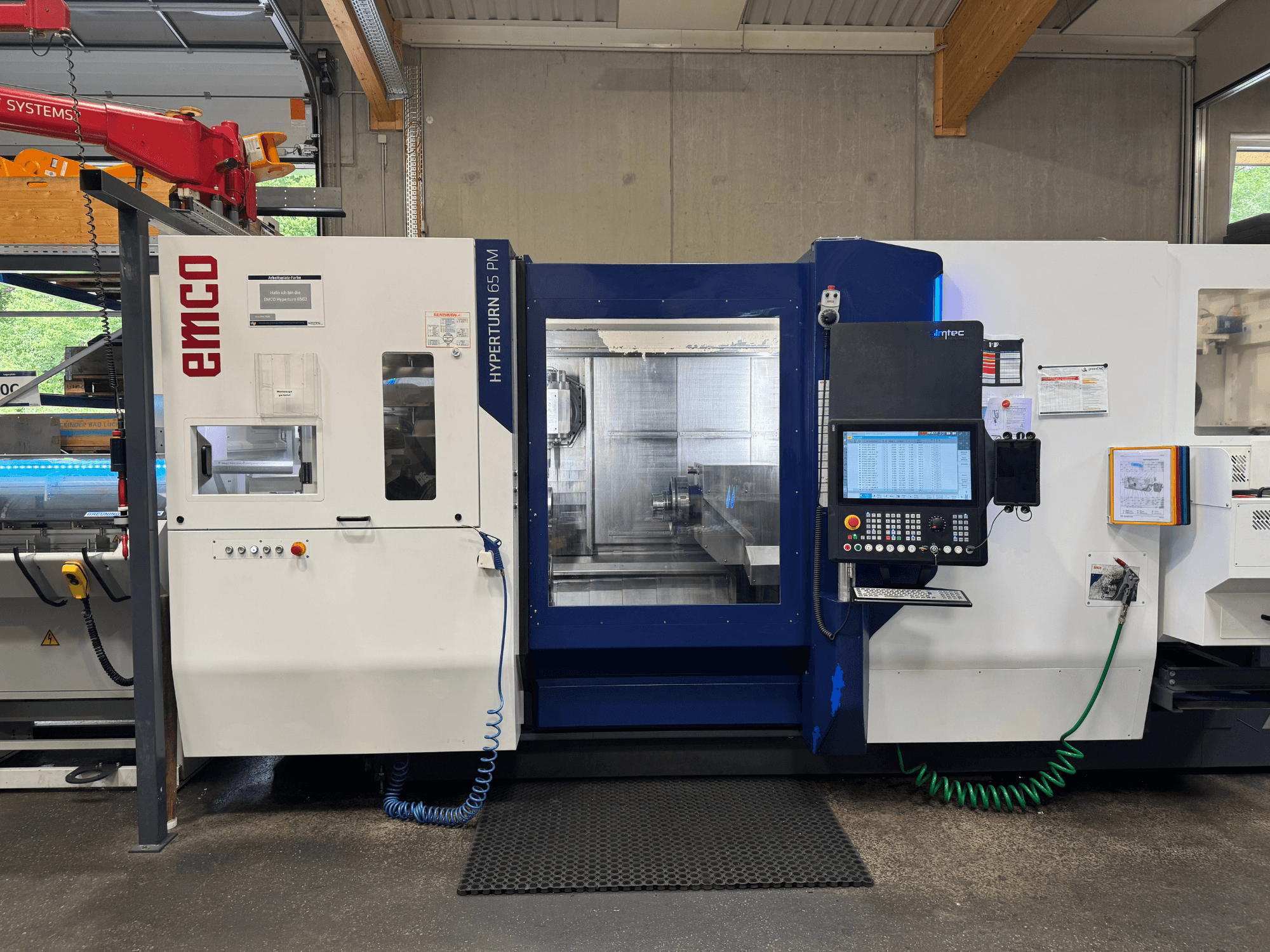 Máquina EMCO Hyperturn 65 PM, vista frontal, mostrando el panel de control, el área del husillo y las características operativas.