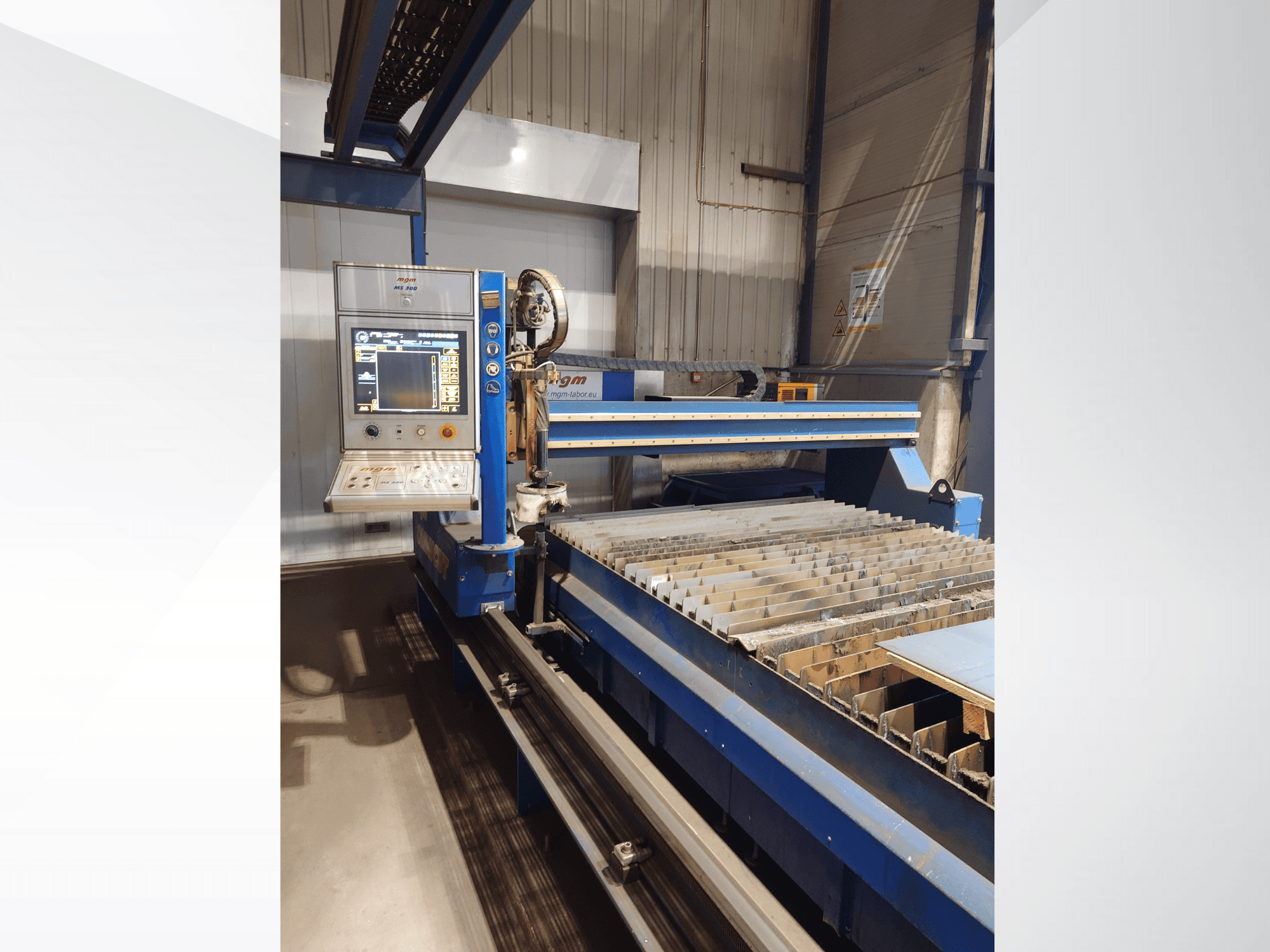 Máquina de corte CNC de PlasmaCam, vista frontal que muestra el panel de control y la bancada de corte de metal con listones.