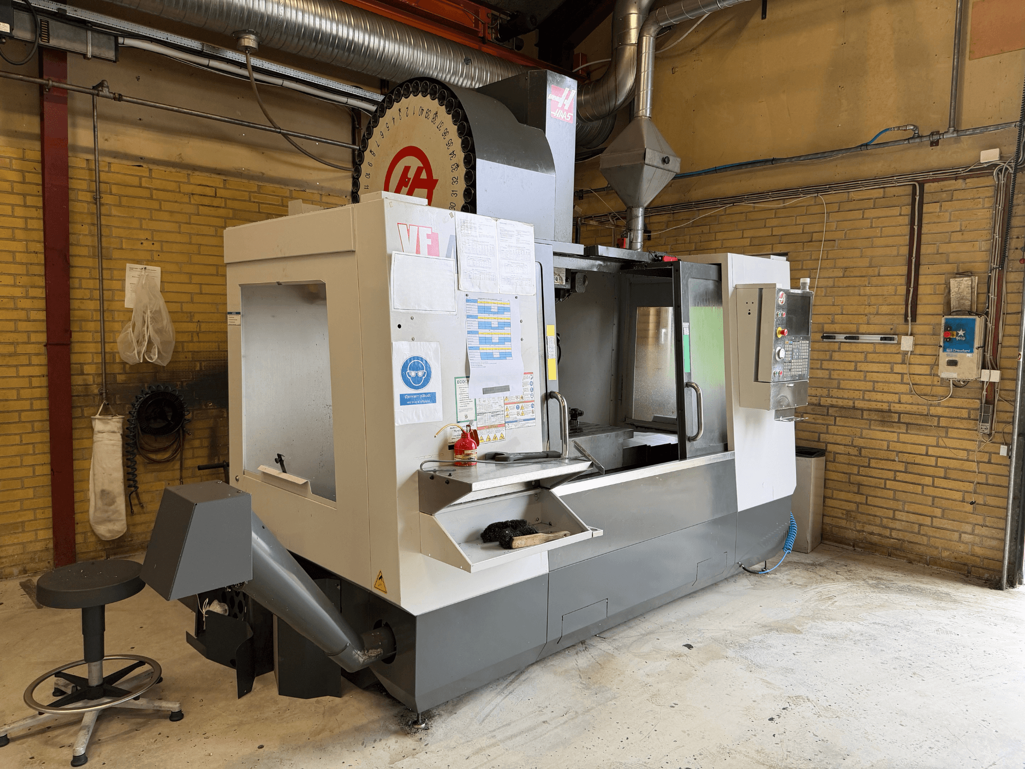 Centro de mecanizado vertical HAAS VF-4, vista frontal; en primer plano se aprecia el panel de control y el portaherramientas, y al fondo, la configuración de producción.