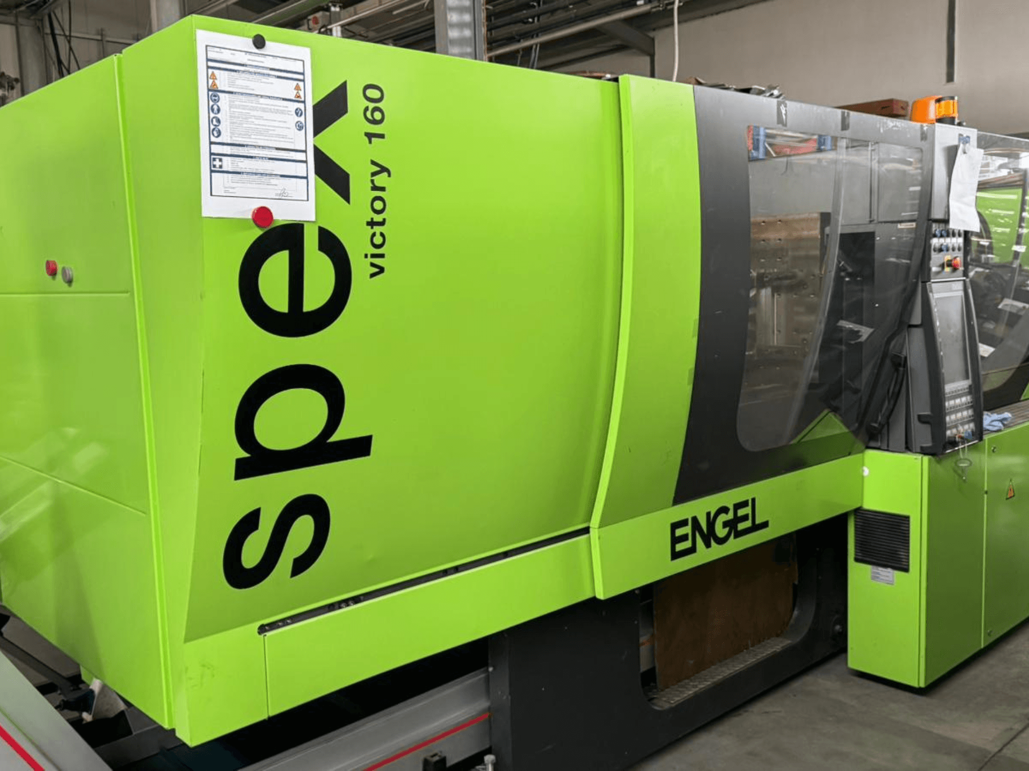 Verde brillante ENGEL Victory 160 máquina de moldeo por inyección, vista lateral, cuenta con panel de control y señalización de seguridad visible.