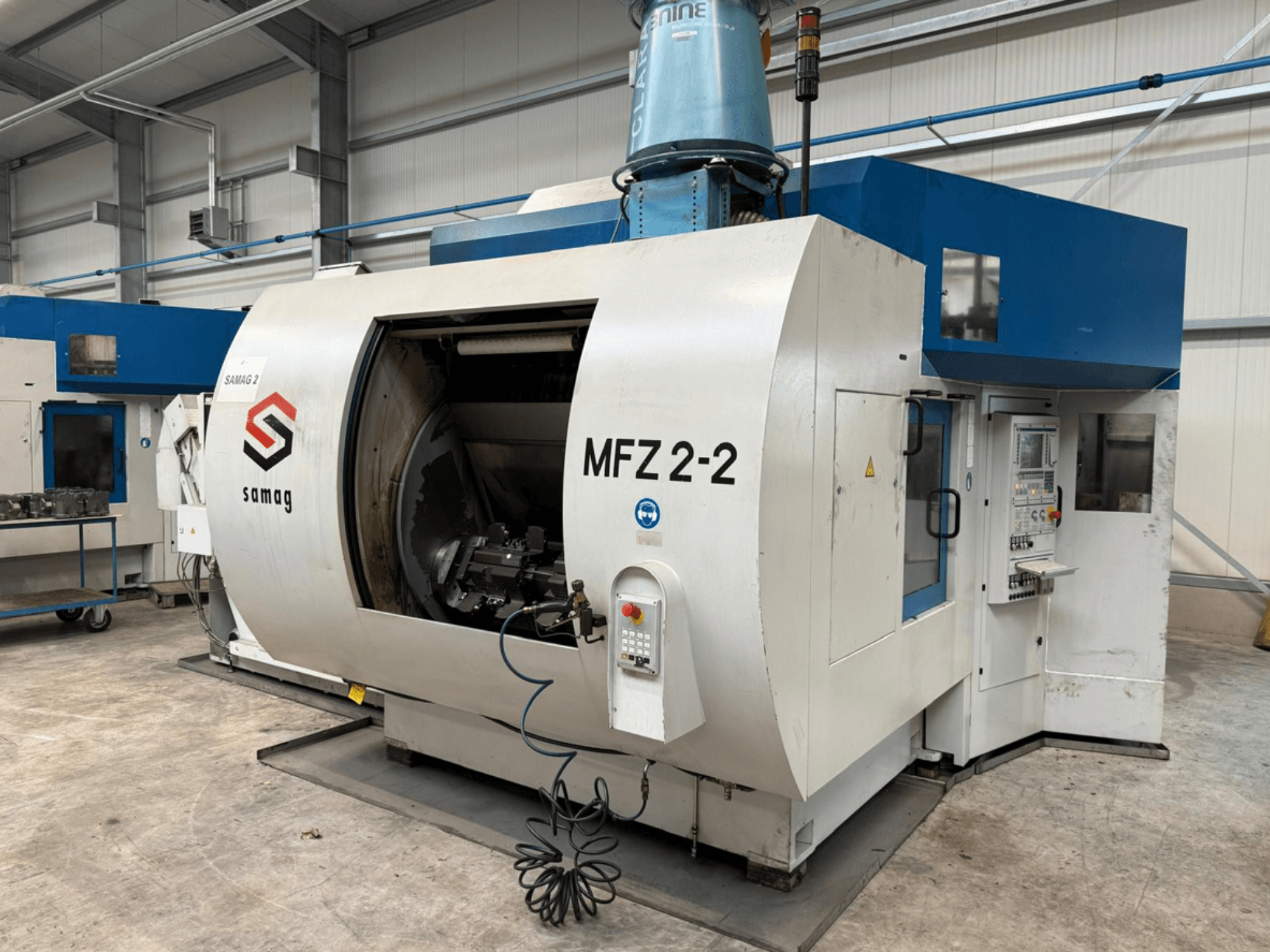 Fresadora Samag MFZ 2-2 en vista lateral, mostrando una gran cámara abierta y un panel de control con varios botones y mandos.