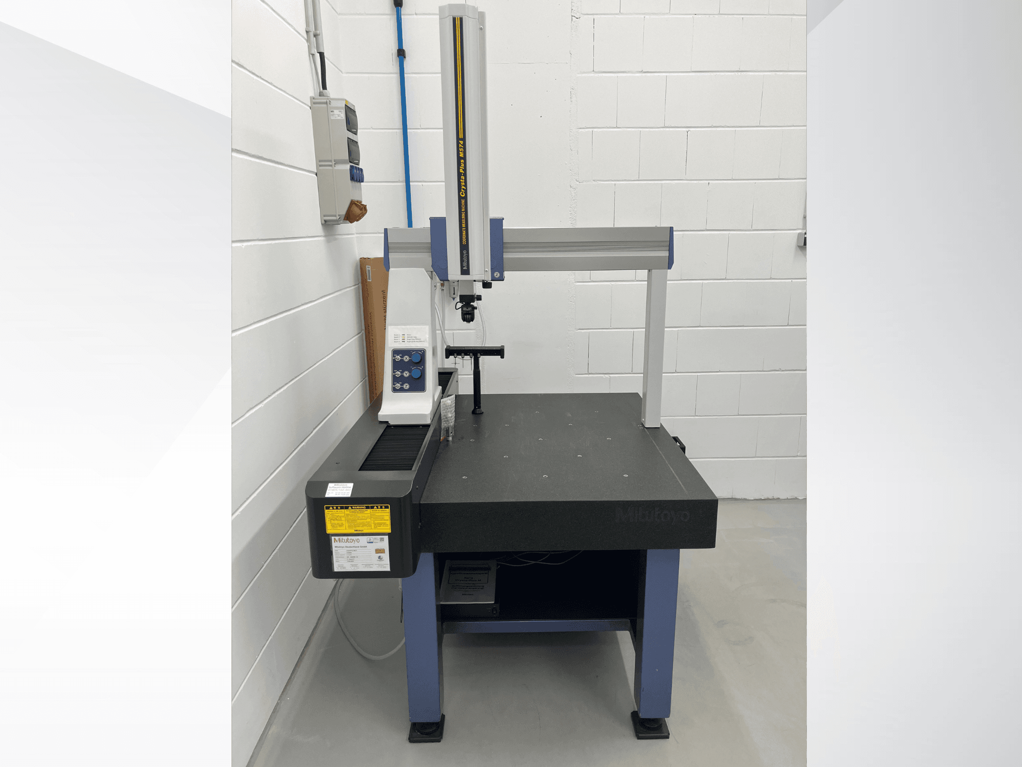 Máquina de medición por coordenadas Mitutoyo Crysta-Plus M574, vista frontal; cuenta con un puente de medición horizontal y un panel de control.