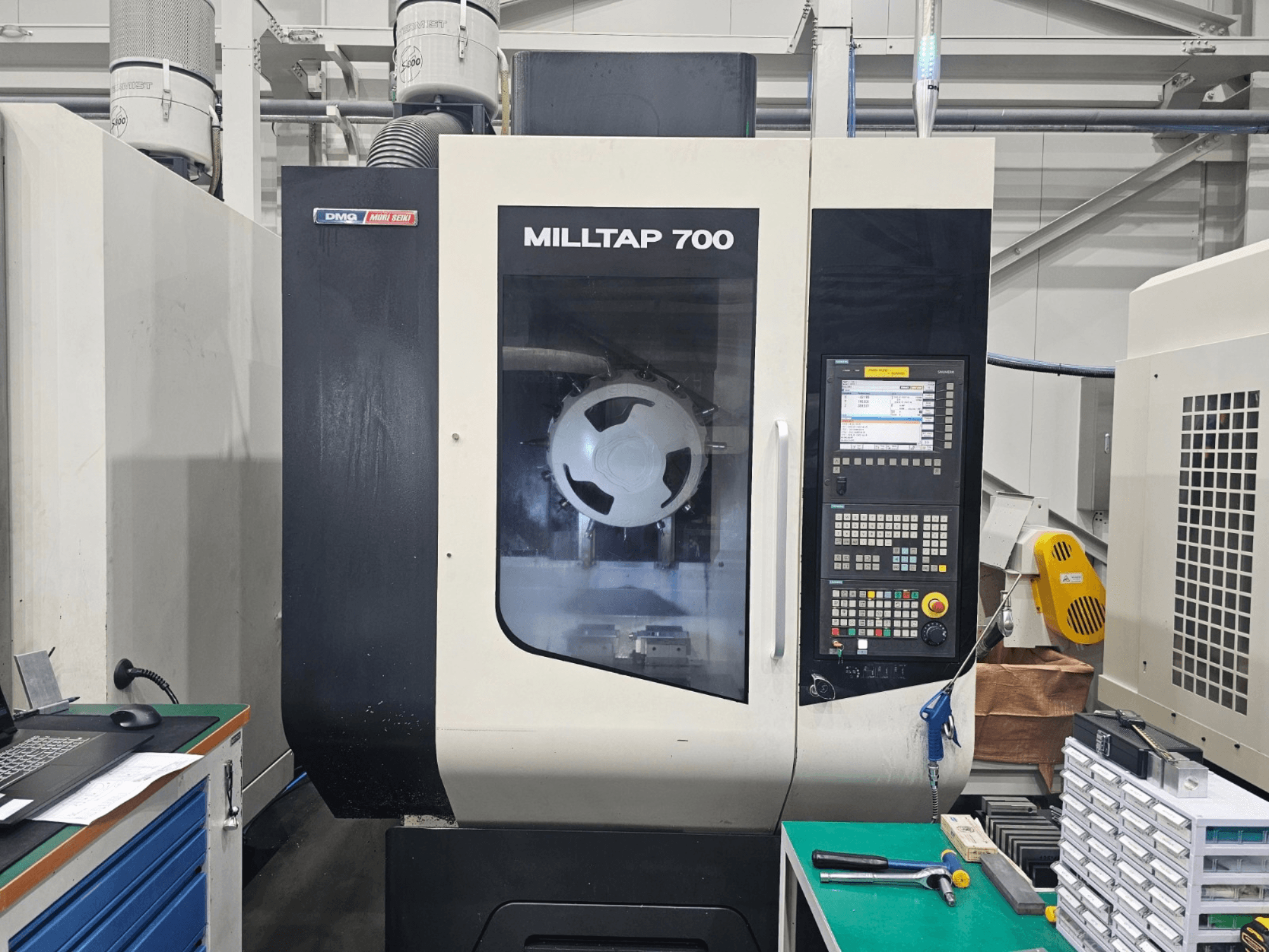 Centro de mecanizado vertical DMG MORI MILLTAP 700, vista frontal, en la que se aprecian detalles del panel de control, el husillo y el espacio de trabajo.