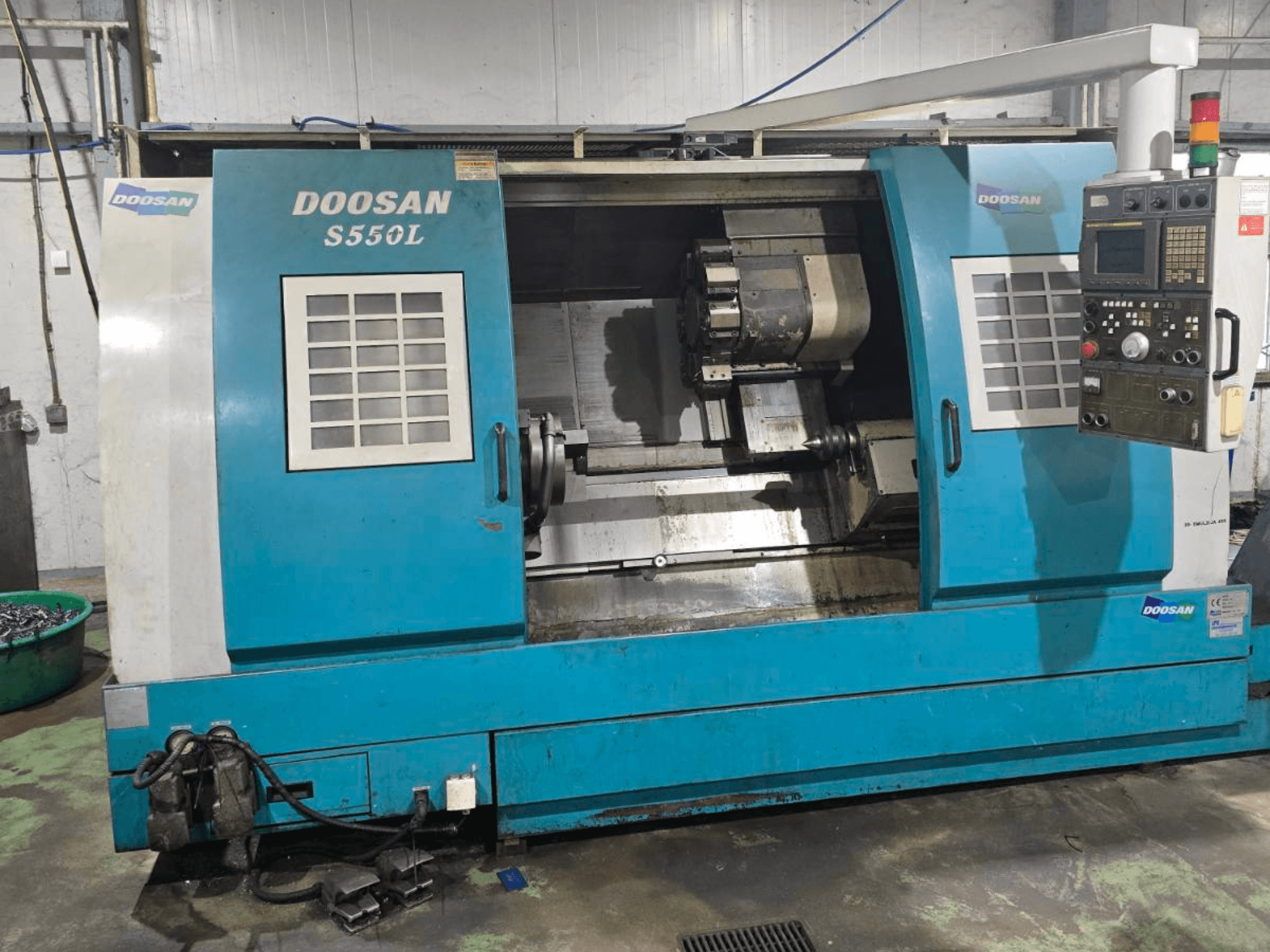 Torno horizontal DOOSAN S550L en vista lateral, con panel de control y bancada de torno, ideal para el mecanizado de precisión.