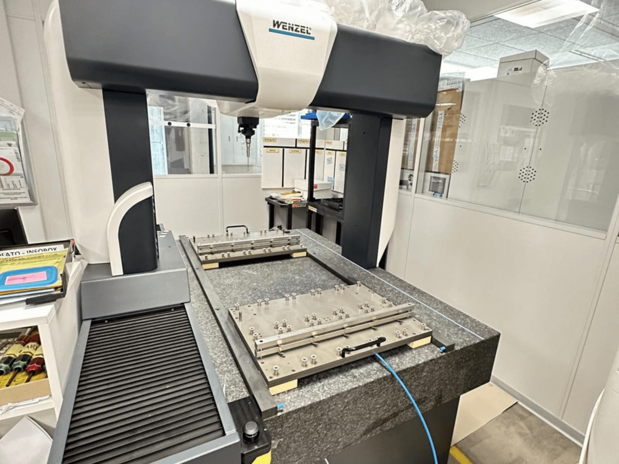 Máquina de medición por coordenadas (CMM) Wenzel LH 65 en un entorno de laboratorio, que presenta una base de granito con una plataforma de medición ajustable y un brazo superior.