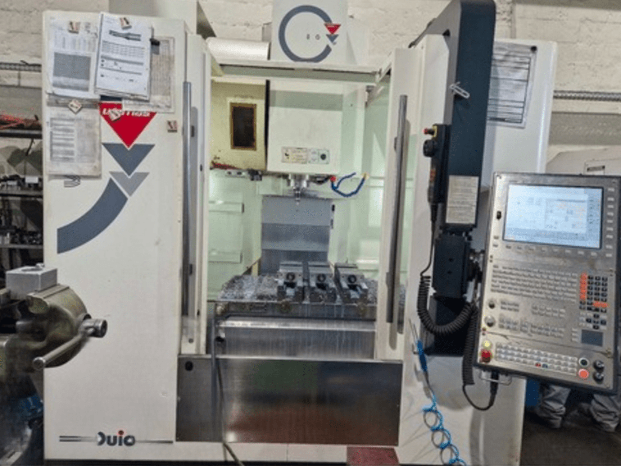 Vista frontal del centro de mecanizado vertical WEMAS VZ 860, con panel de control e interfaz CNC, con documentación adjunta.