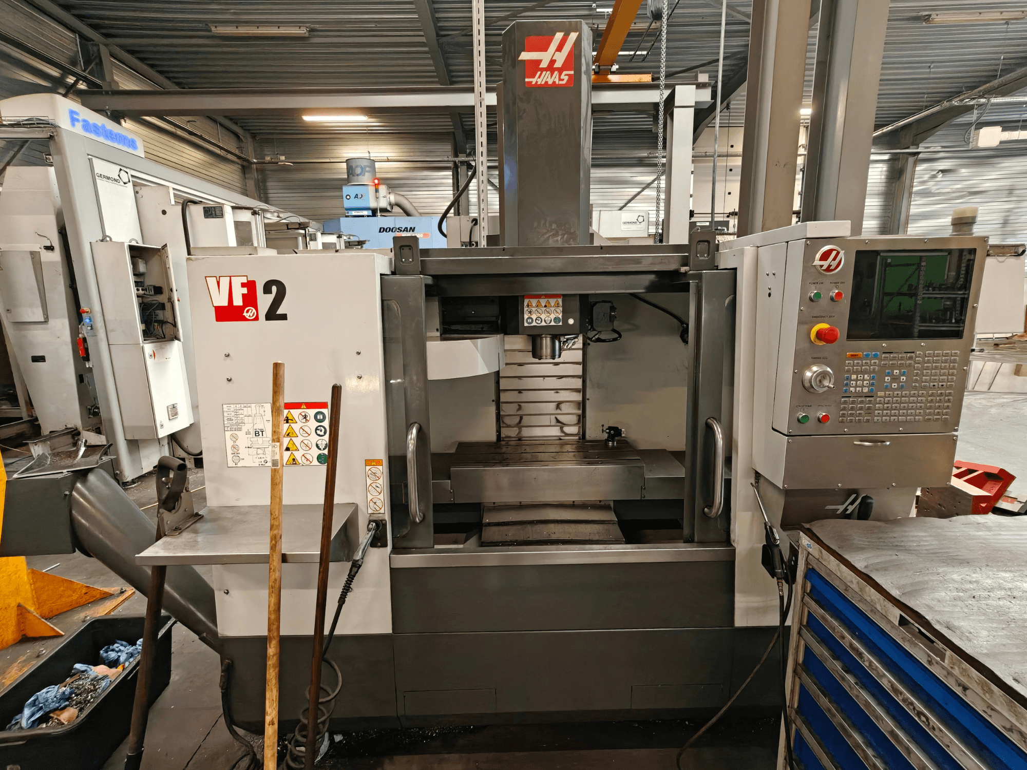Centro de mecanizado vertical HAAS VF-2, vista frontal, en la que se aprecian los mandos, el husillo y la mesa de trabajo en un entorno de taller.