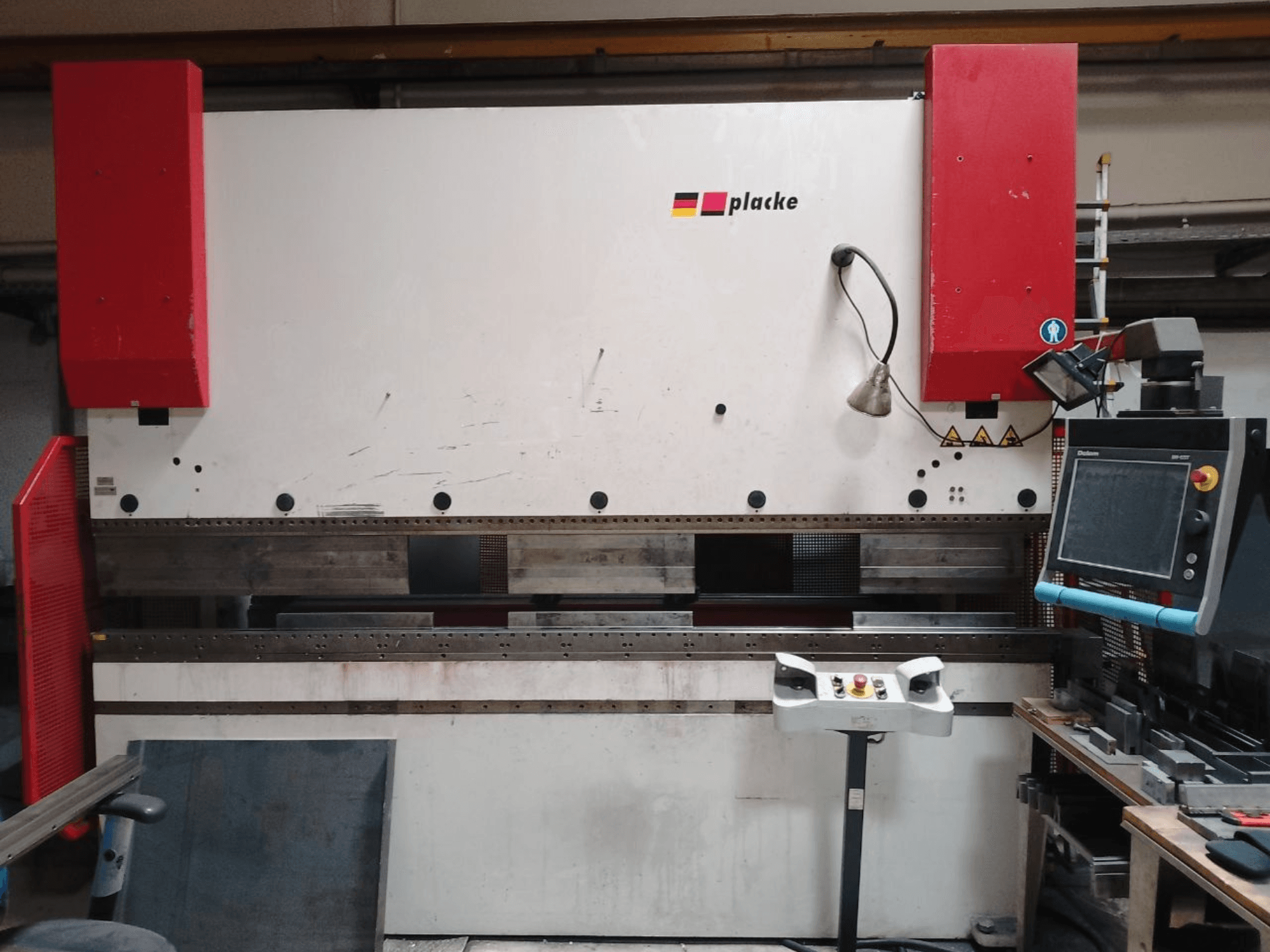 Plegadora PLACKE QPB-4 150/3100, vista frontal en la que se aprecian el panel de control, los brazos rojos y la zona de plegado de metal.