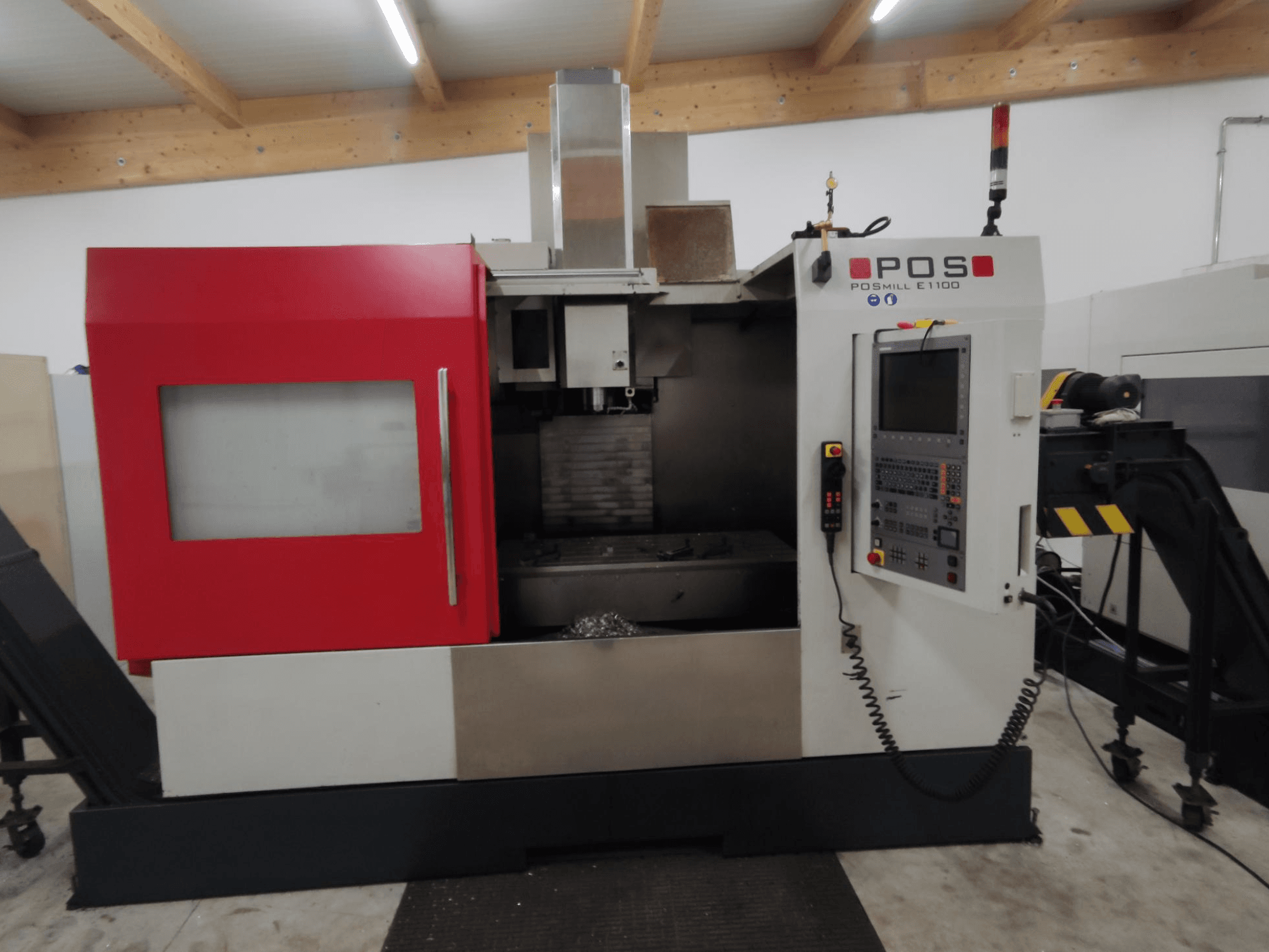 Fresadora CNC POSMILL E1100 en vista frontal con carcasa roja, panel de control y luz de seguridad en la parte superior.
