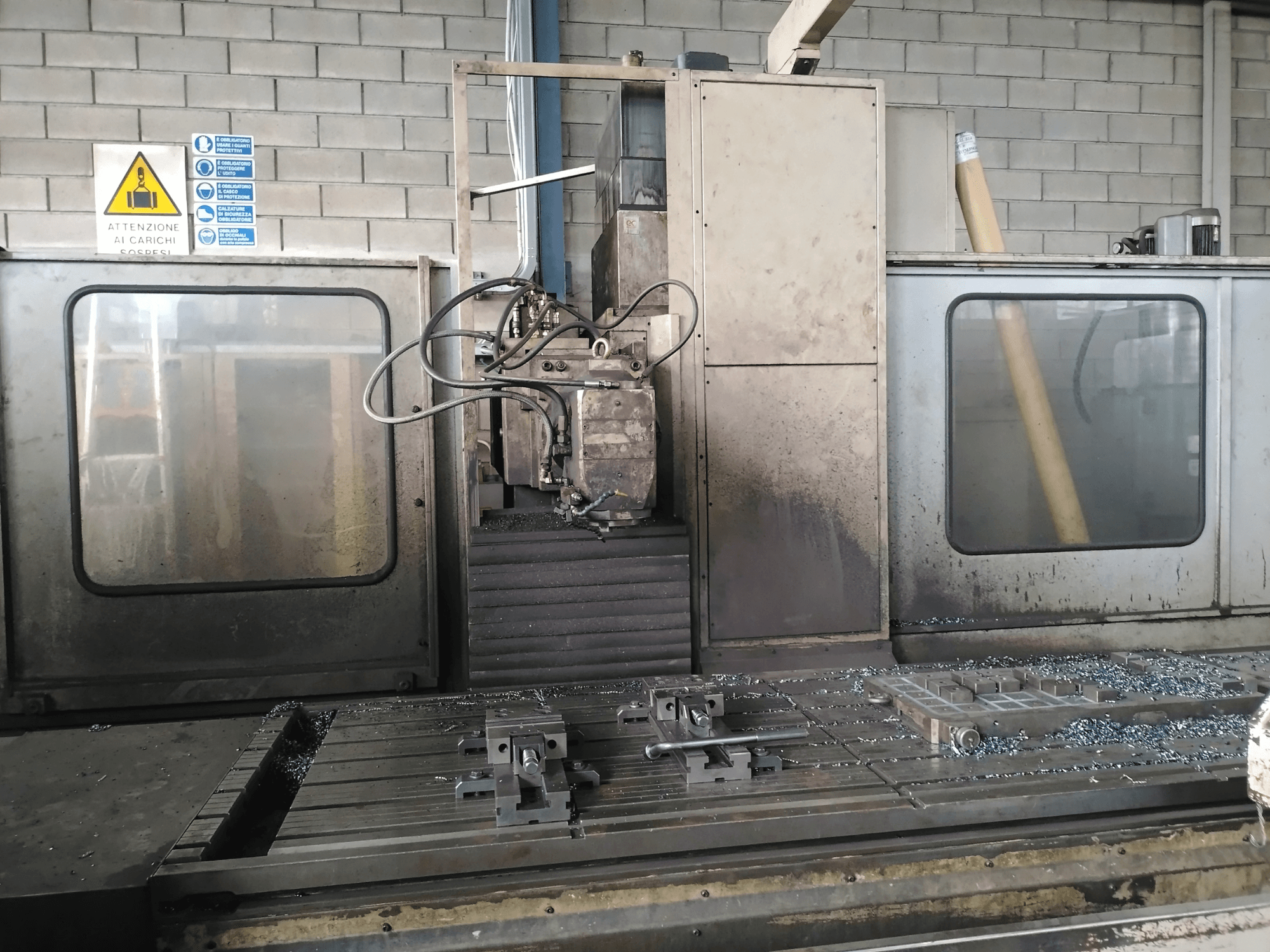 Fresadora de bancada TIGER TFA6 en un taller, vista frontal mostrando herramientas y virutas de metal sobre la mesa.